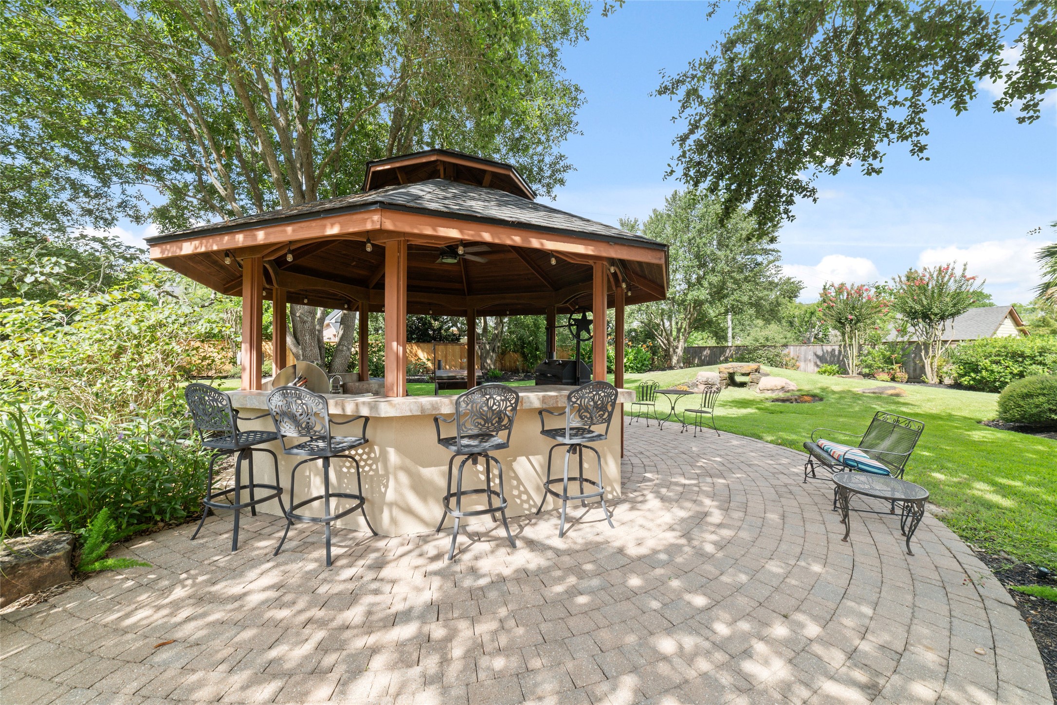 Spacious covered gazebo with bar seating offers a peaceful outdoor retreat.
