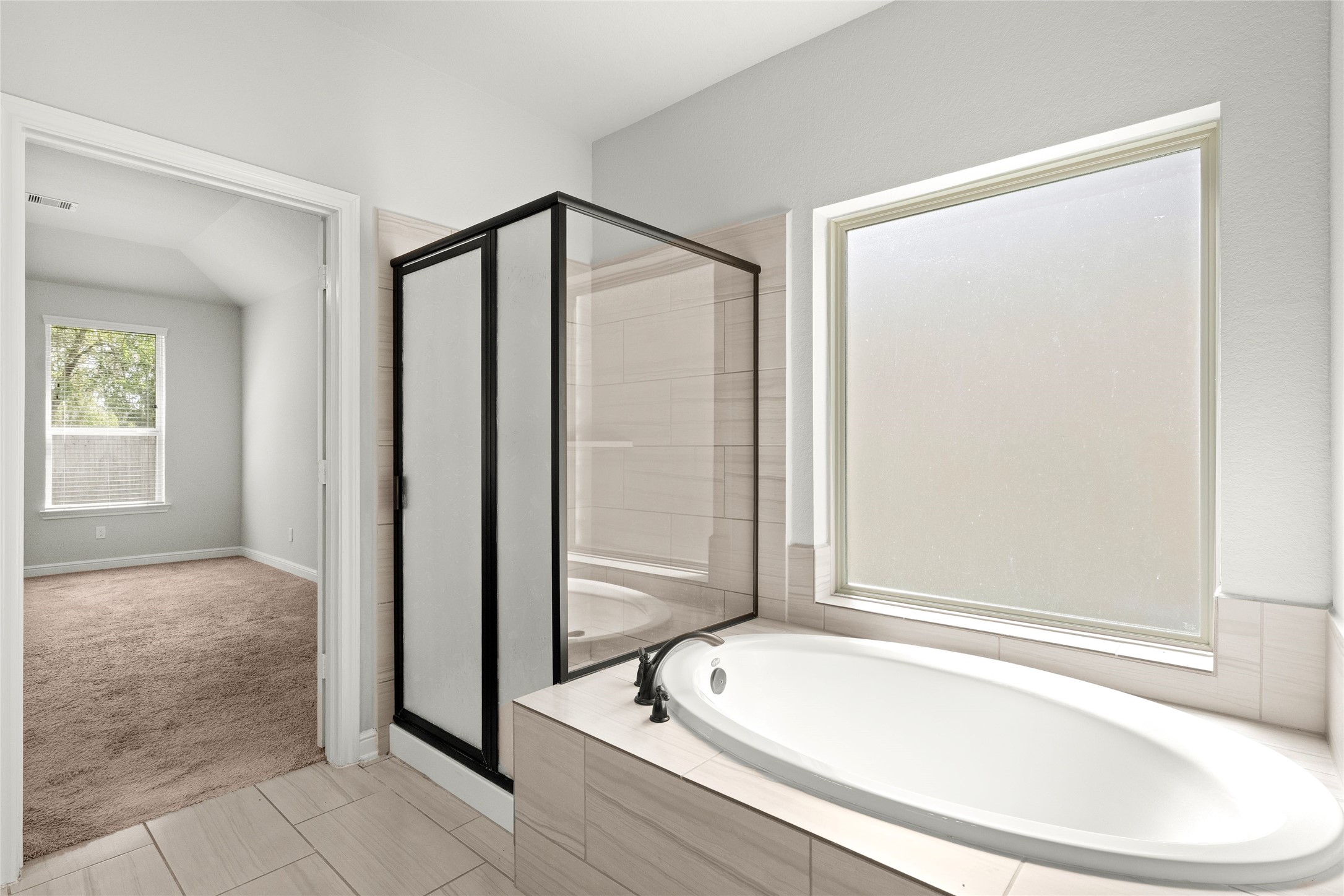 Spa-like primary bath with garden tub and glass shower