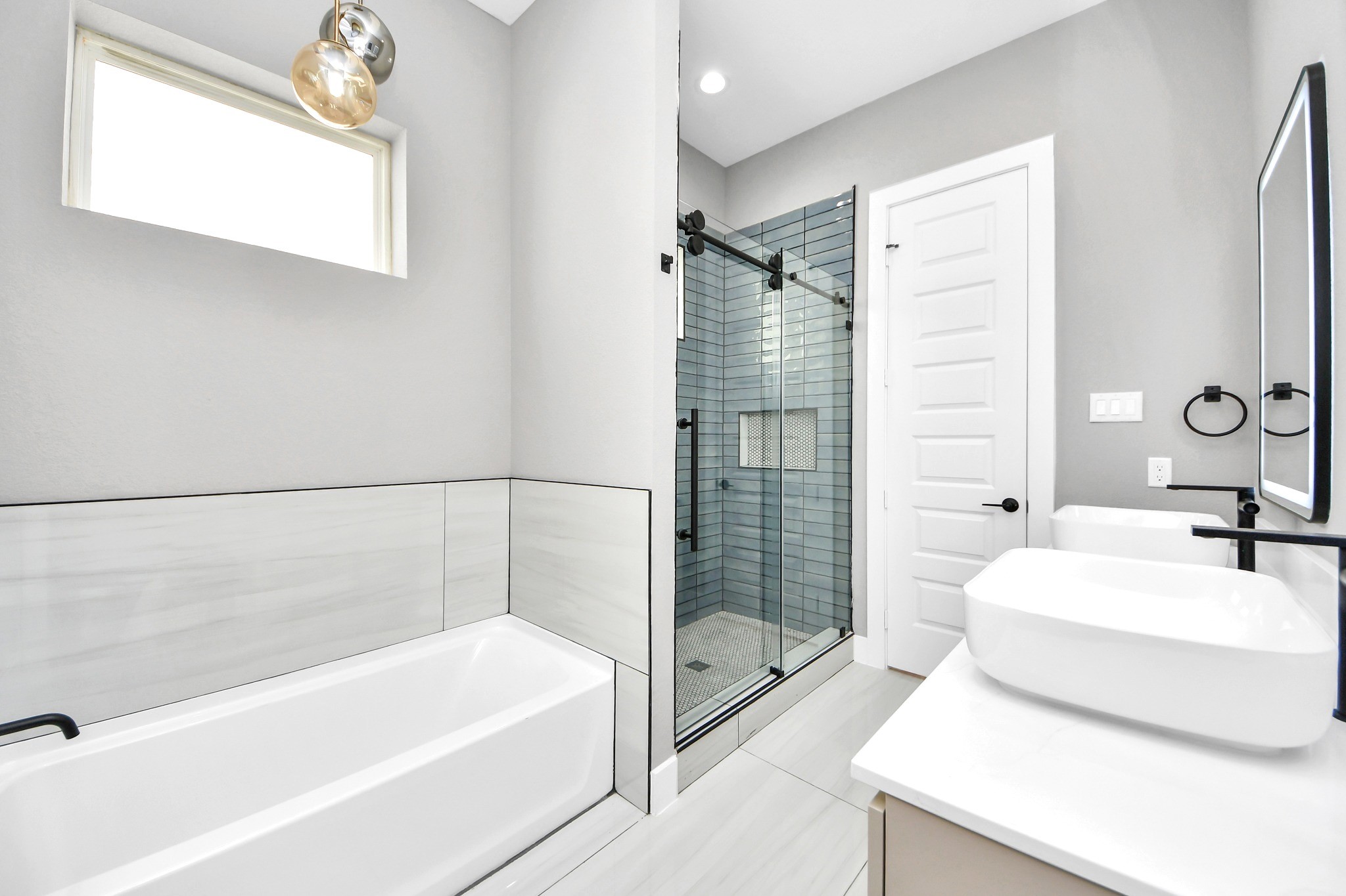 The primary bathroom delivers a serene modern setting with dual sinks, generous storage and elevated finishes.