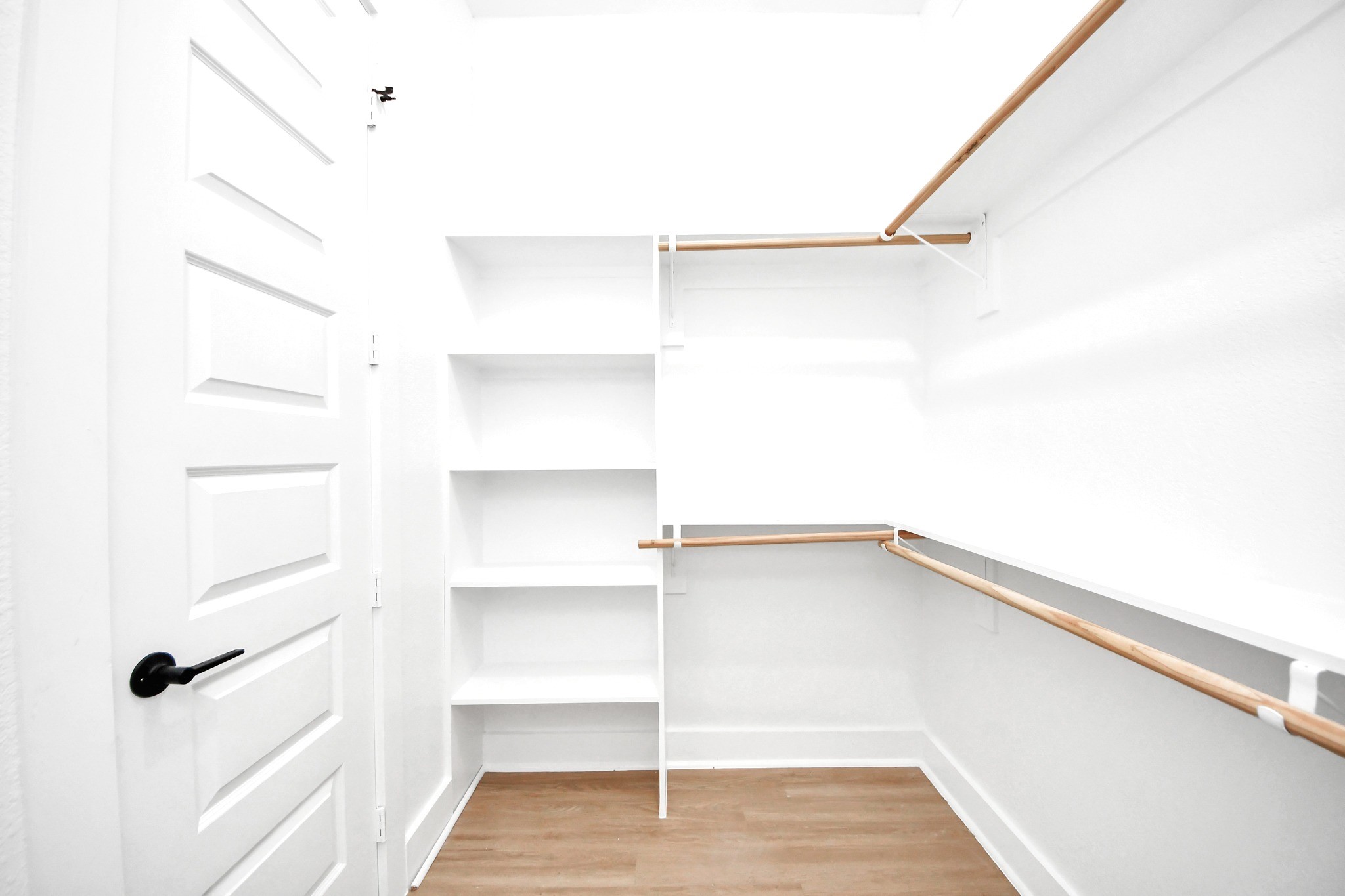 Built-in shelving transforms the primary walk-in closet into a practical, organized dressing space.