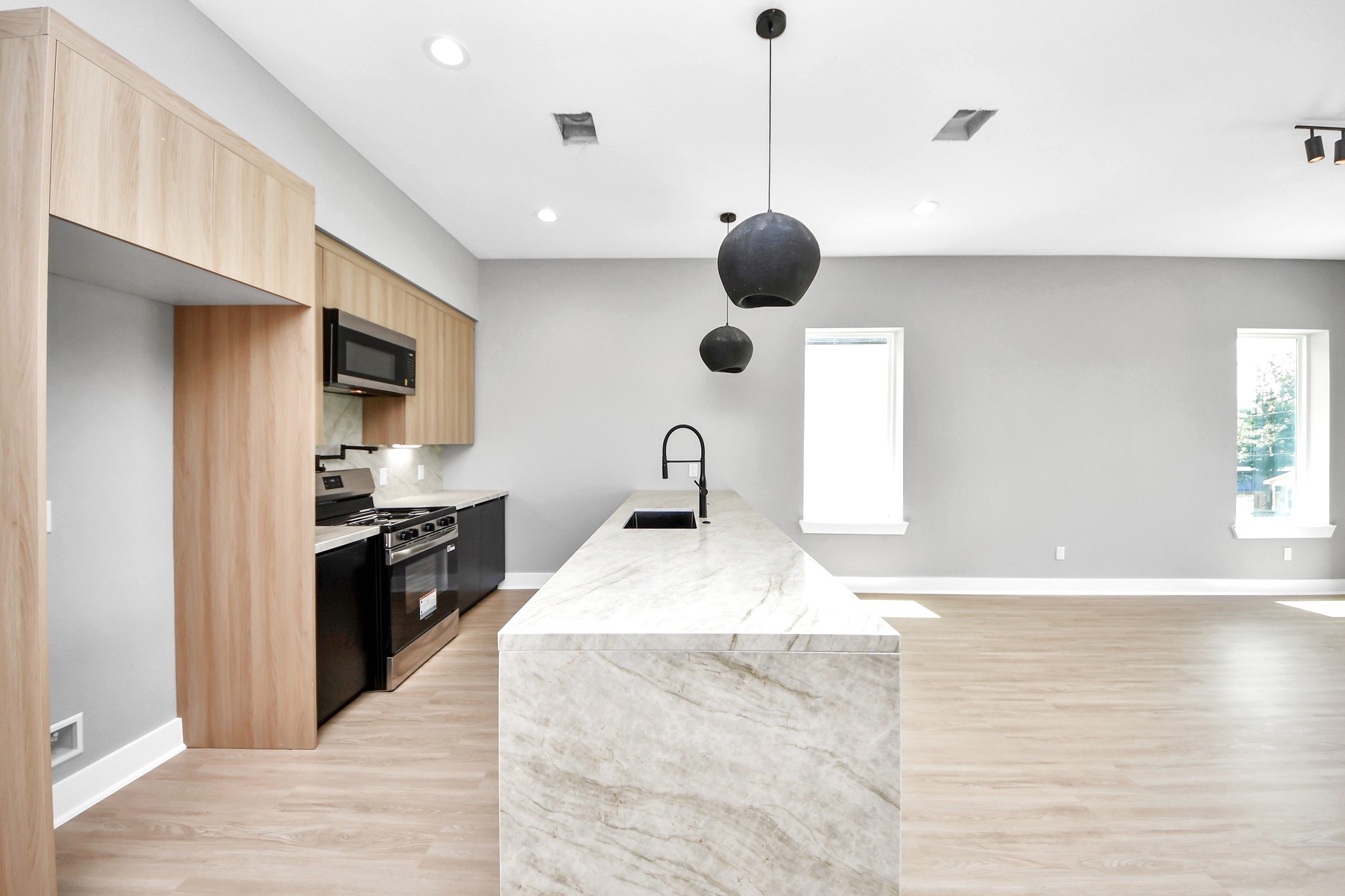 A dramatic waterfall-edge island anchors Unit Cs designer kitchen and creates an effortless gathering space.
