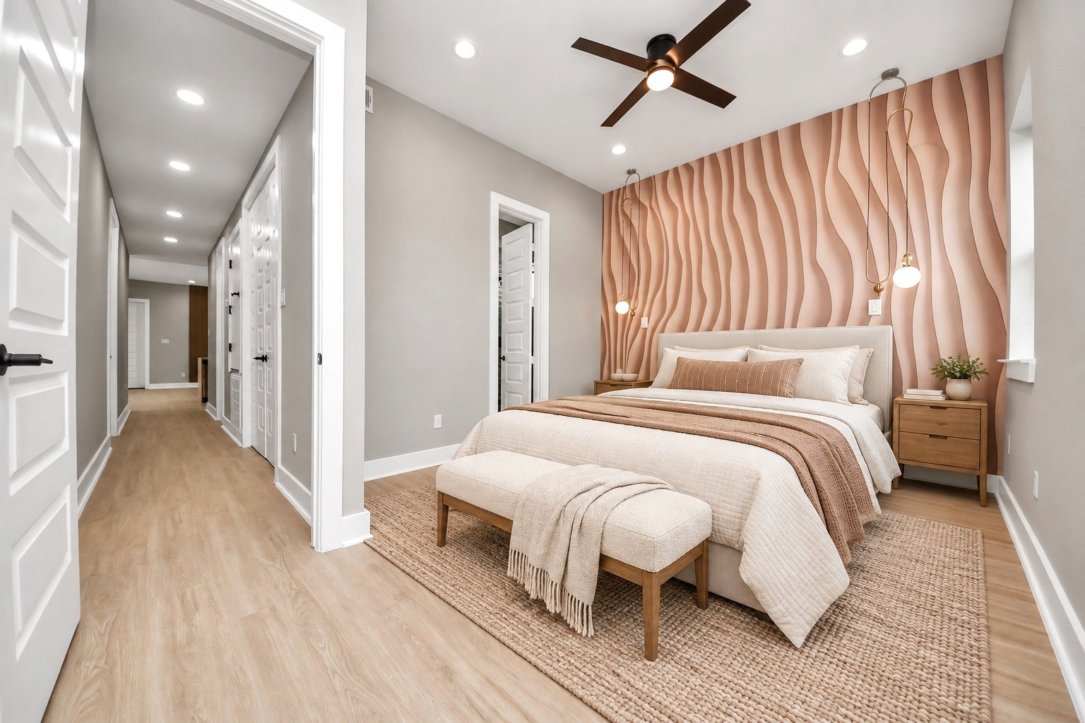 Unit Ds primary bedroom becomes a warm retreat against its sculptural accent wall and designer lighting