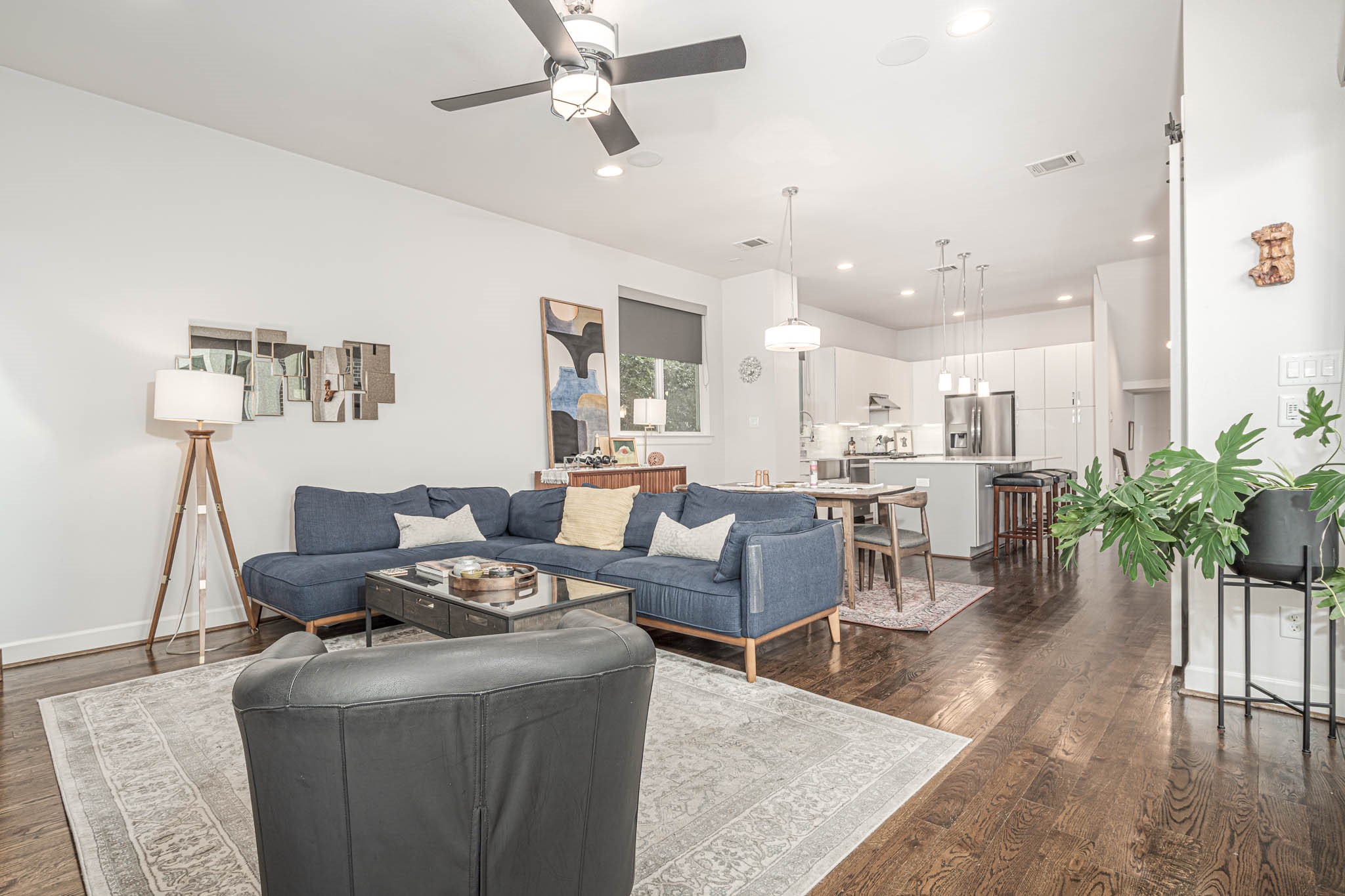 Discover a spacious, open-concept living area with sleek hardwood floors, a modern kitchen with stainless steel appliances, and ample natural light. The cozy seating area and stylish decor create an inviting atmosphere for relaxation and entertaining.