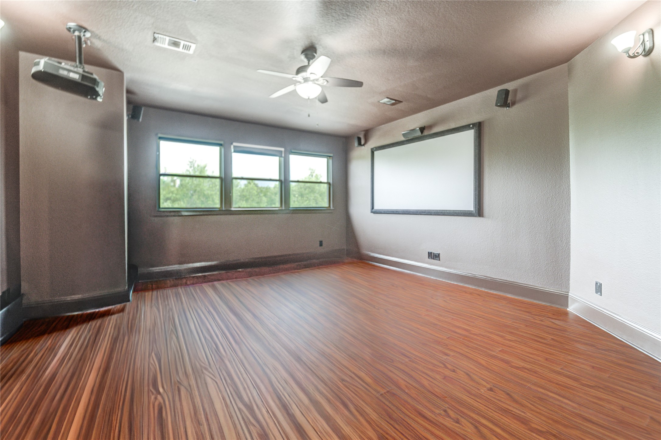 A luxurious second-floor media room, complete with a projector and large screen, perfect for cinematic entertainment.