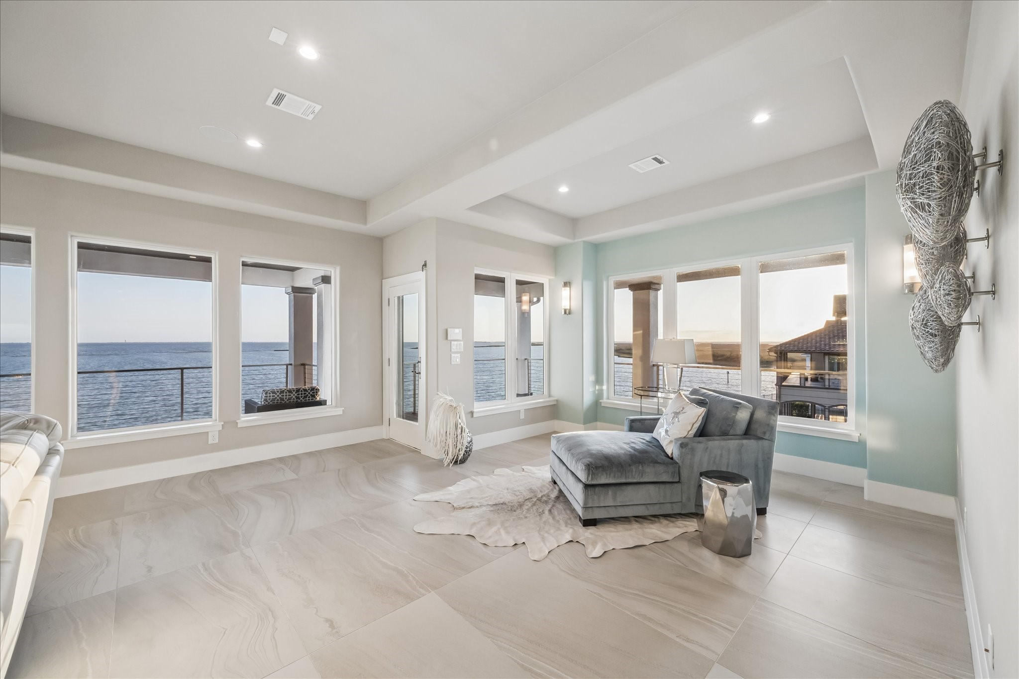 The secondary sitting area adjacent to the family room offers a versatile living space, enhanced design functionality, and additional waterfront views