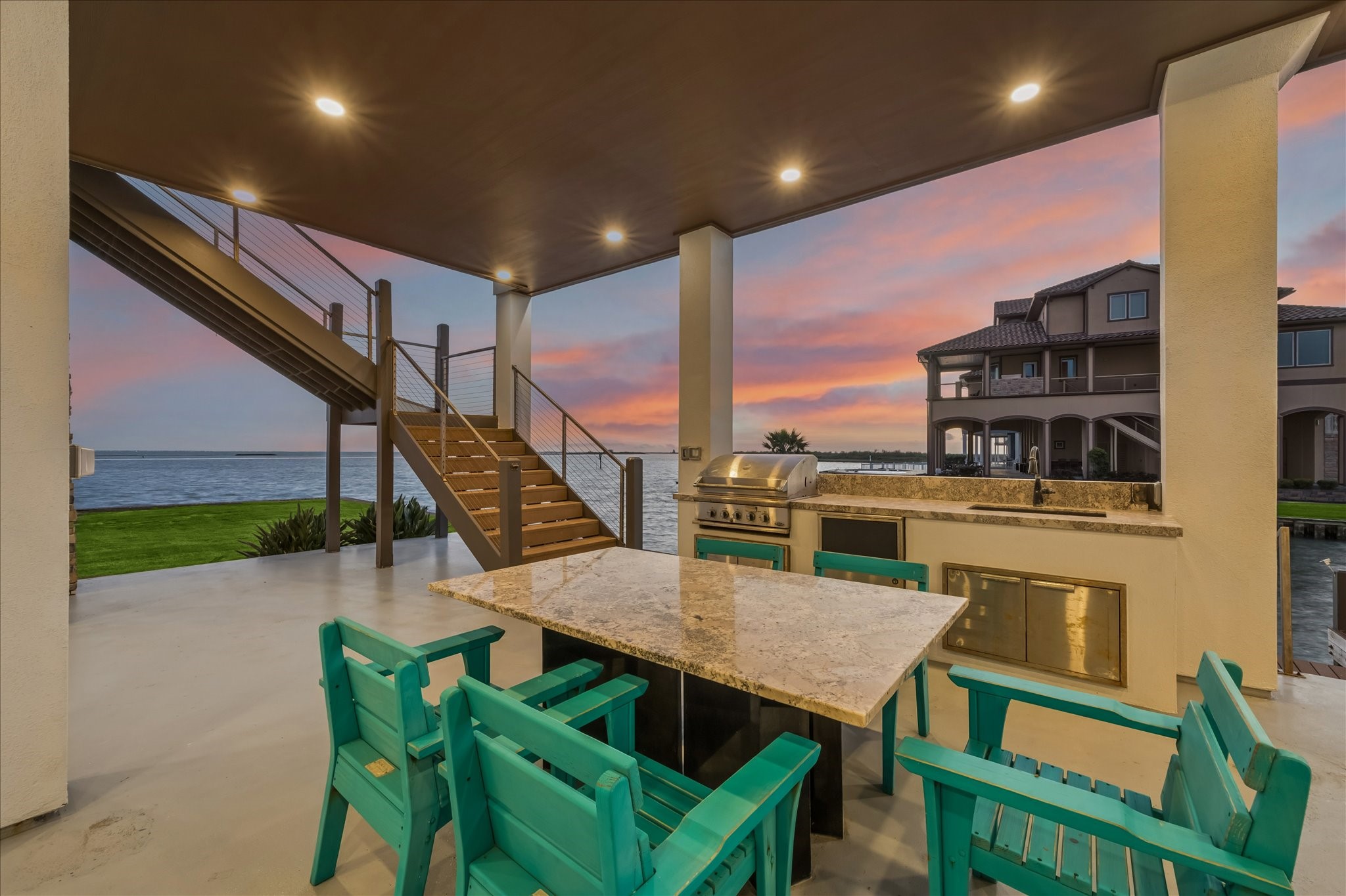 The ground-level entertaining space impresses with a covered lounge, outdoor kitchen, and custom built in table just steps from the bulkhead. Whether hosting sunset gatherings or launching from your back door, this home captures the best of Texas Gulf Coast living