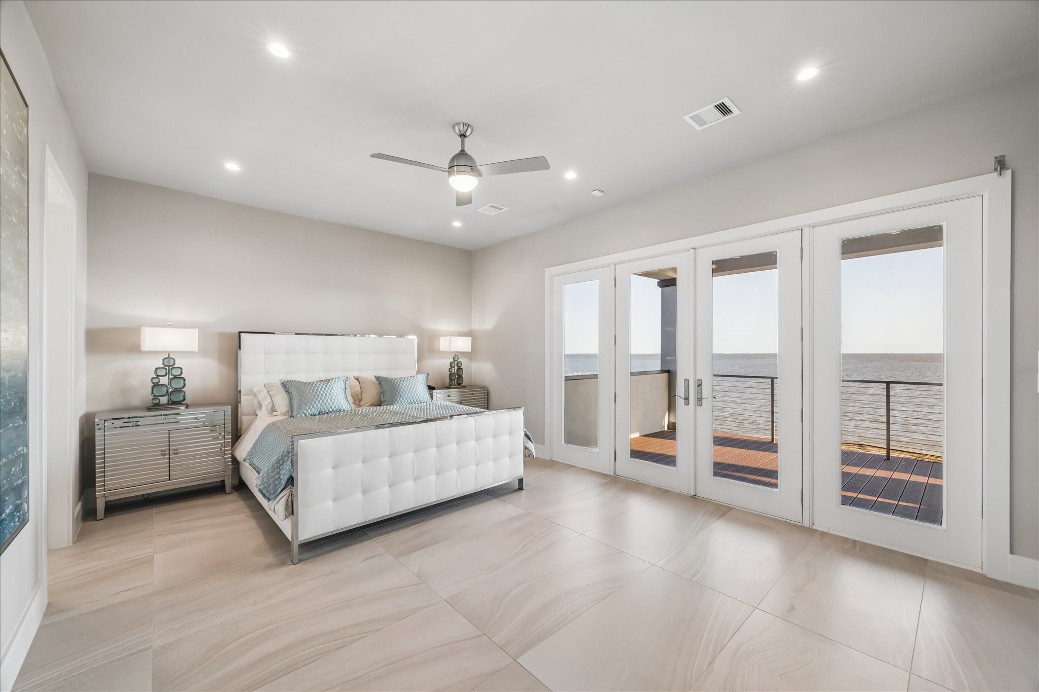 Step into the serene primary suite designed as a true sanctuary, where French doors open directly onto a the covered balcony for waking up to panoramic bay views