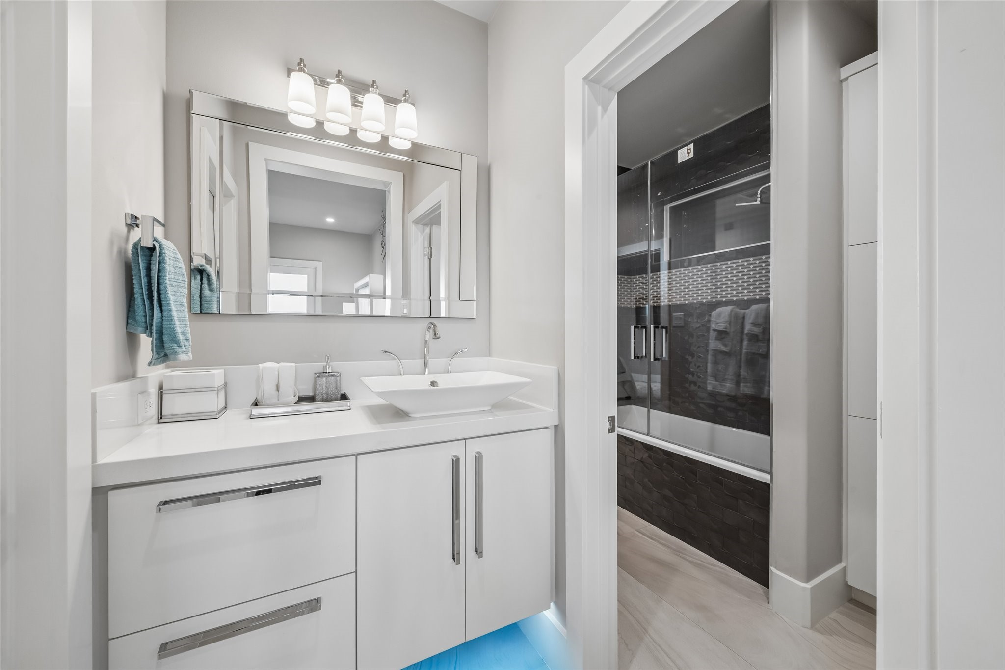 The second and third guest bedrooms access a Jack & Jill bathroom, with each bedroom featuring its own vanity complete with quartz countertops and under-vanity lighting