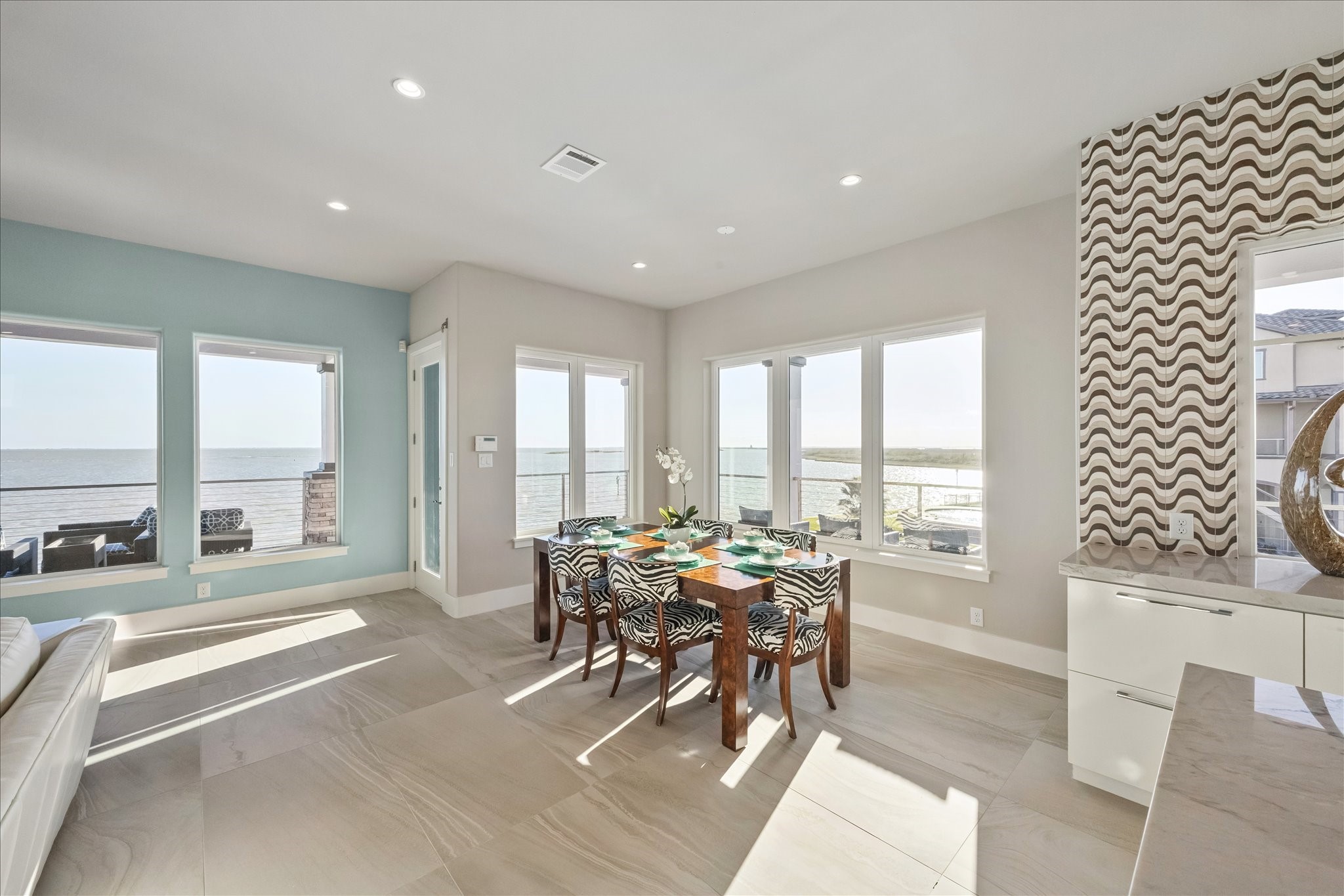 The dining room flows seamlessly with the kitchen and living room, offering a natural connection to the outdoors and ample space for a large gatherings