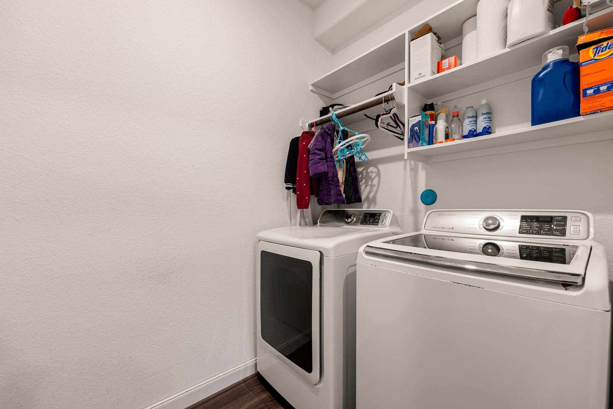 A dedicated laundry space with built-in overhead shelving to keep essentials tidy.