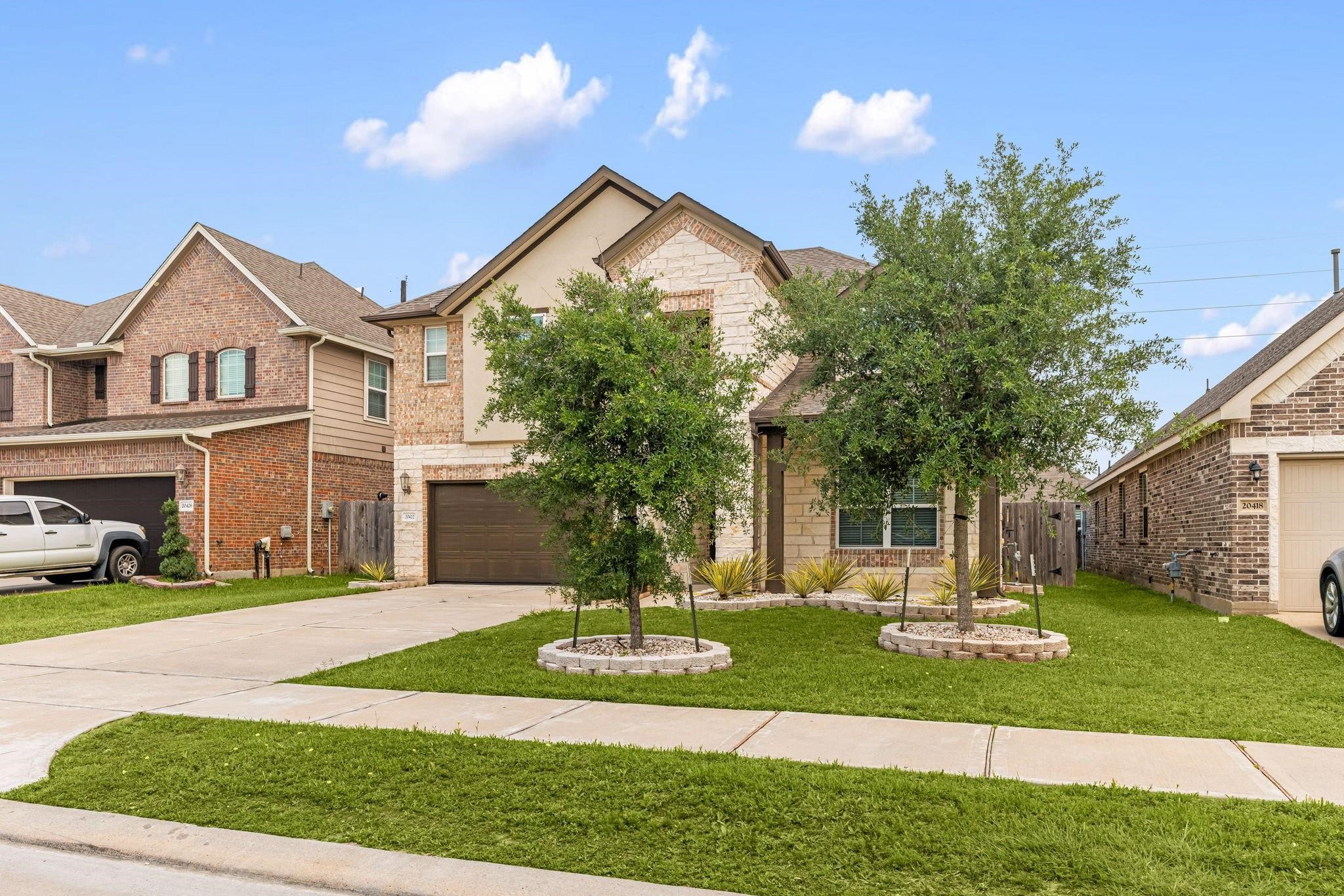 Green grass and young shade trees give the home fantastic curb appeal as you pull up.