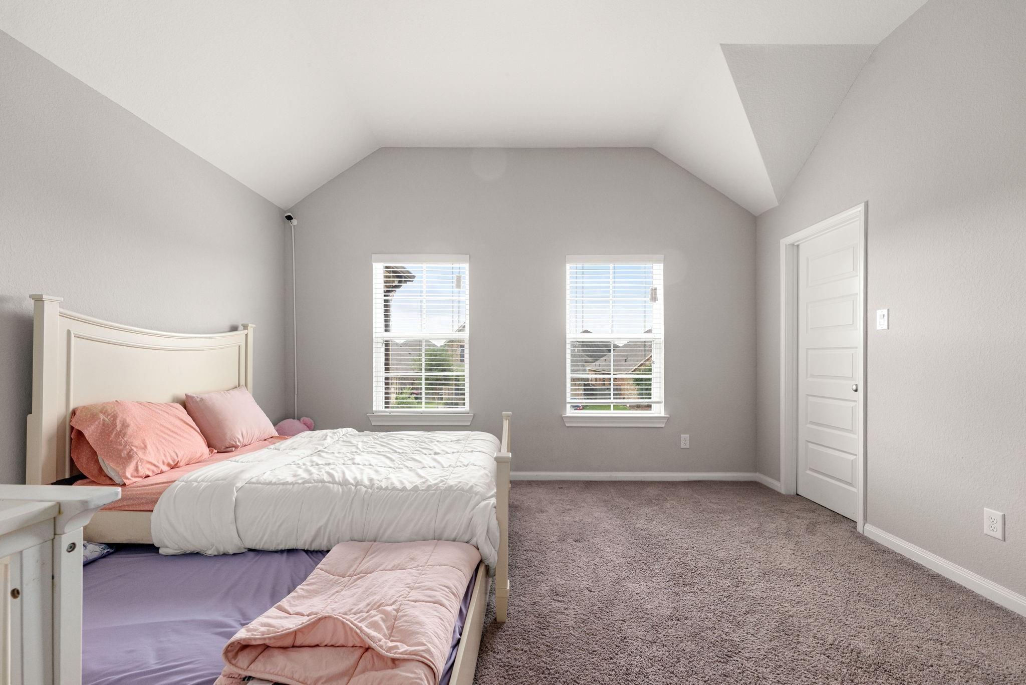 Bright and soothing, this upper-level bedroom offers plush carpeting and plenty of natural light.