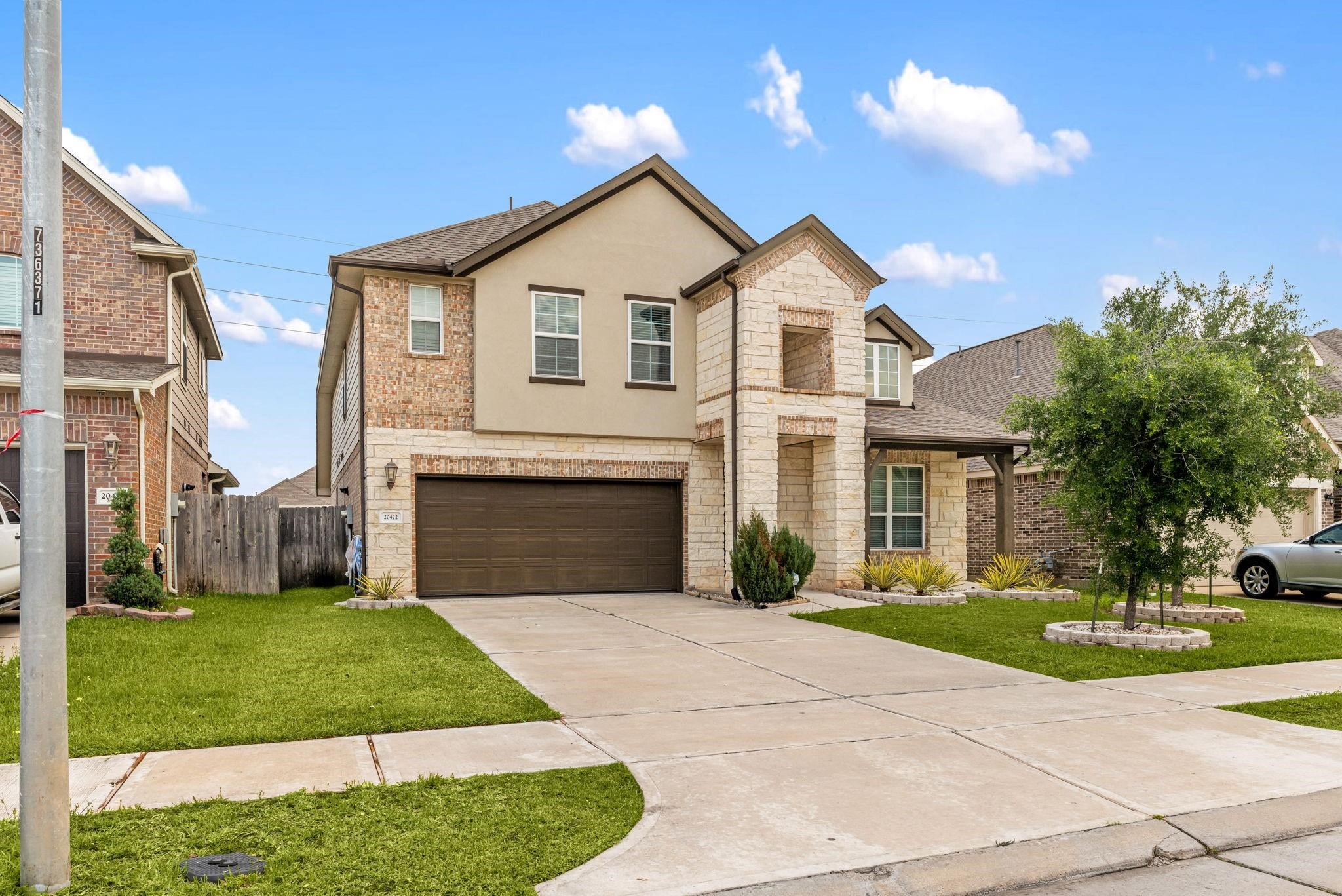 A wide driveway offers plenty of parking space leading up to the two-car garage.