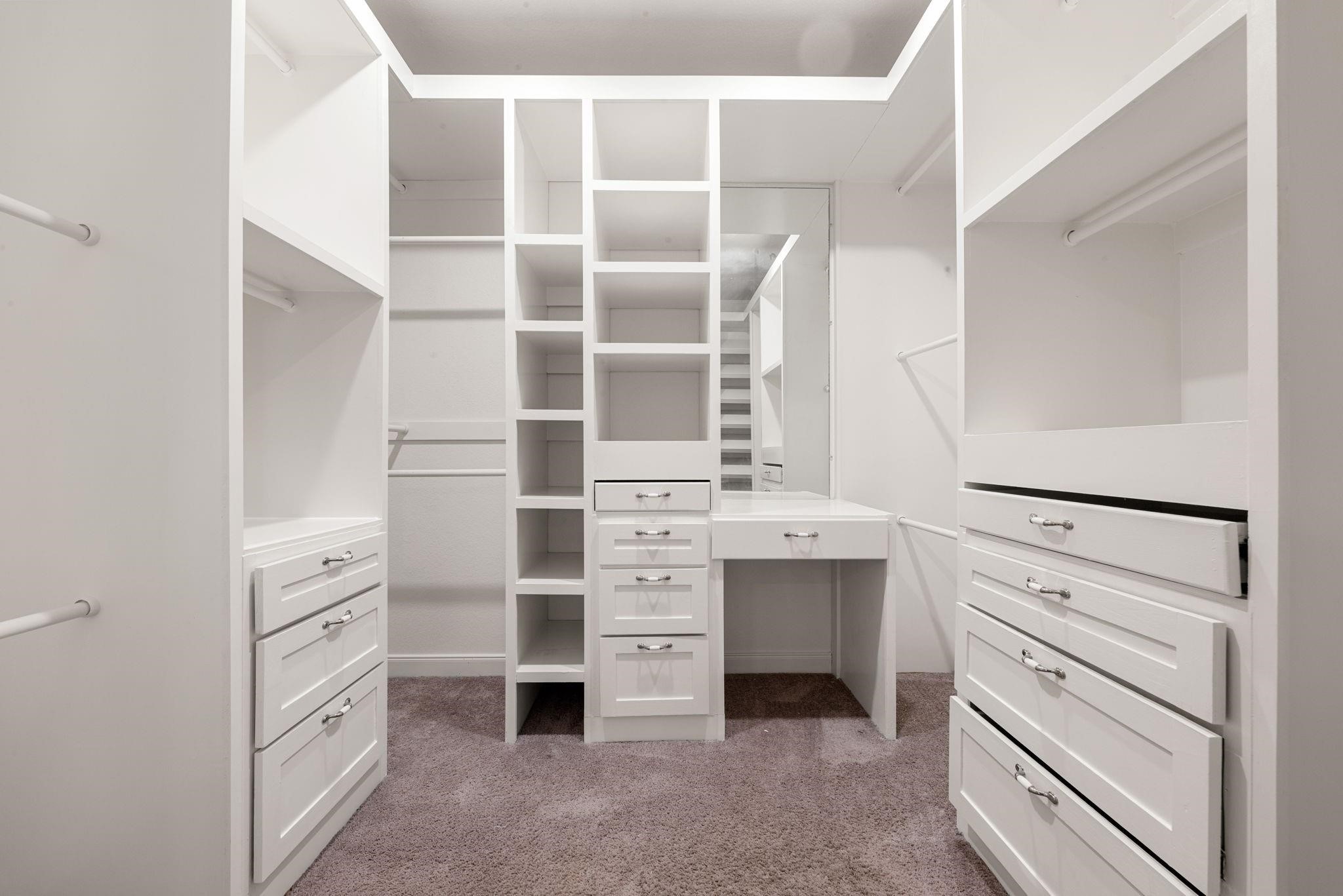 Custom built-in shelving, drawers, and hanging racks keep everything organized and easy to reach in the large full-entry closet.