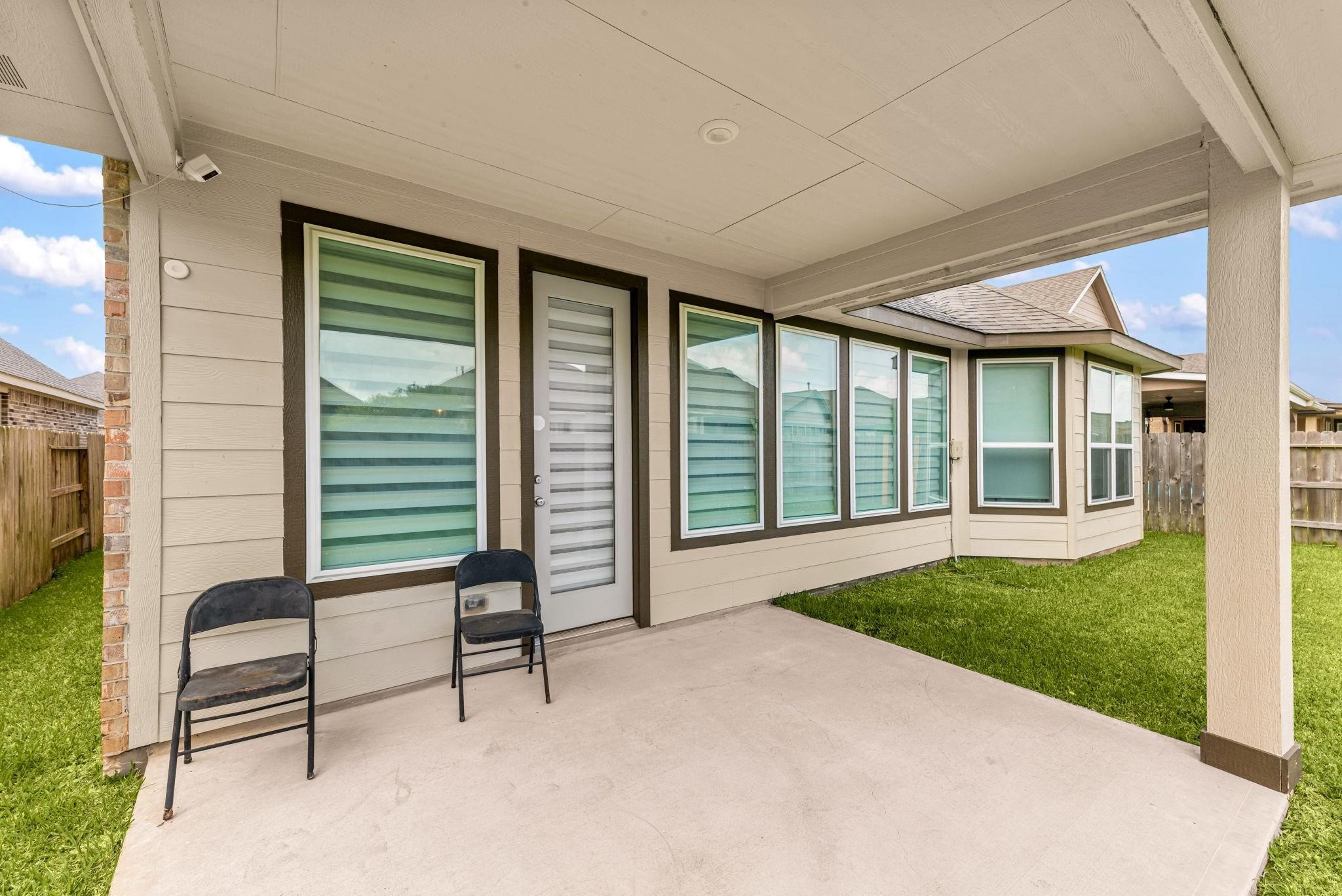 The covered back patio is a great spot to sit outside in the shade and overlook the yard.