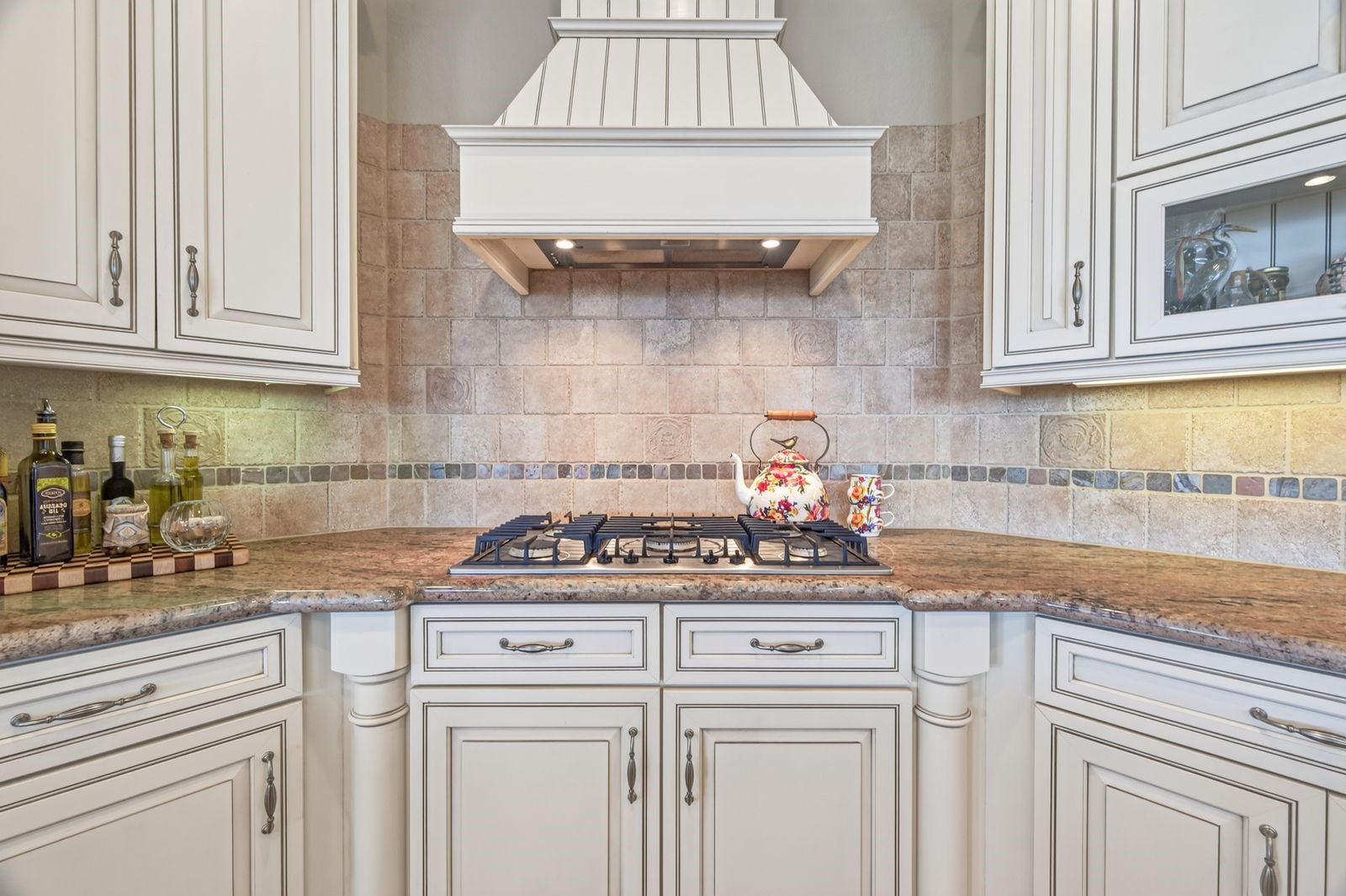Experience culinary bliss in this dream kitchen, featuring custom cabinetry, a stylish vent hood, and elegant undermount lighting.