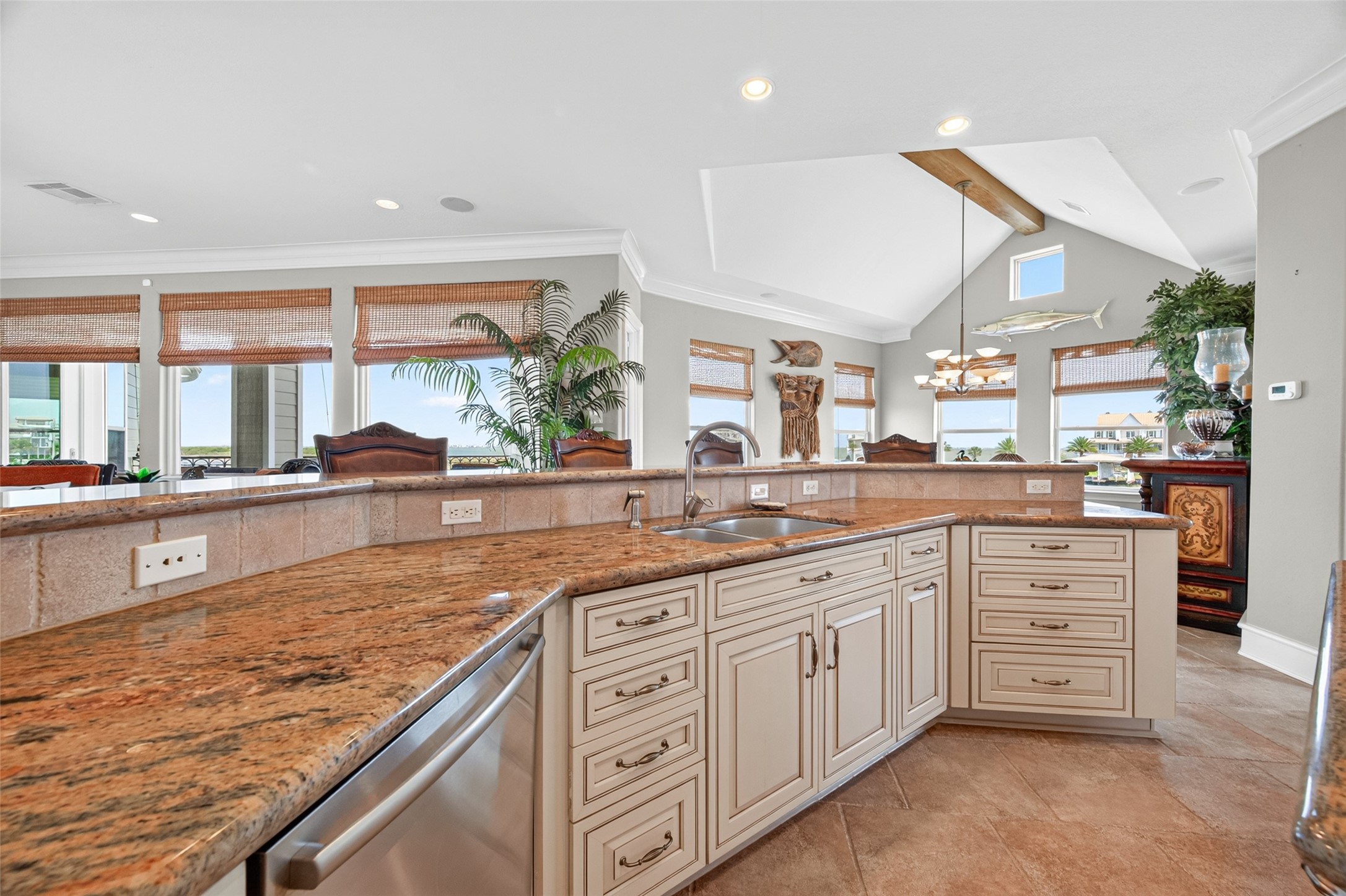 Spacious kitchen with elegant granite countertops, custom cabinetry, and a convenient double sink, complemented by abundant natural light and an open layout perfect for entertaining.