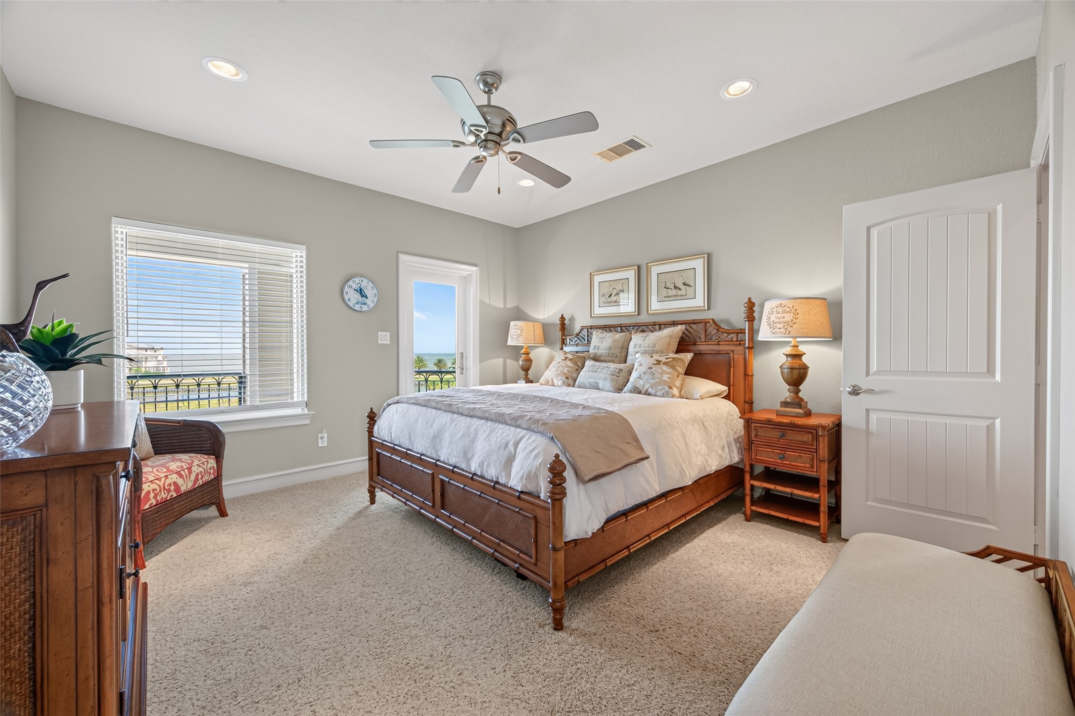 Inviting bedroom with abundant natural light, featuring a cozy bed, elegant wooden furniture, and a calming neutral palette.