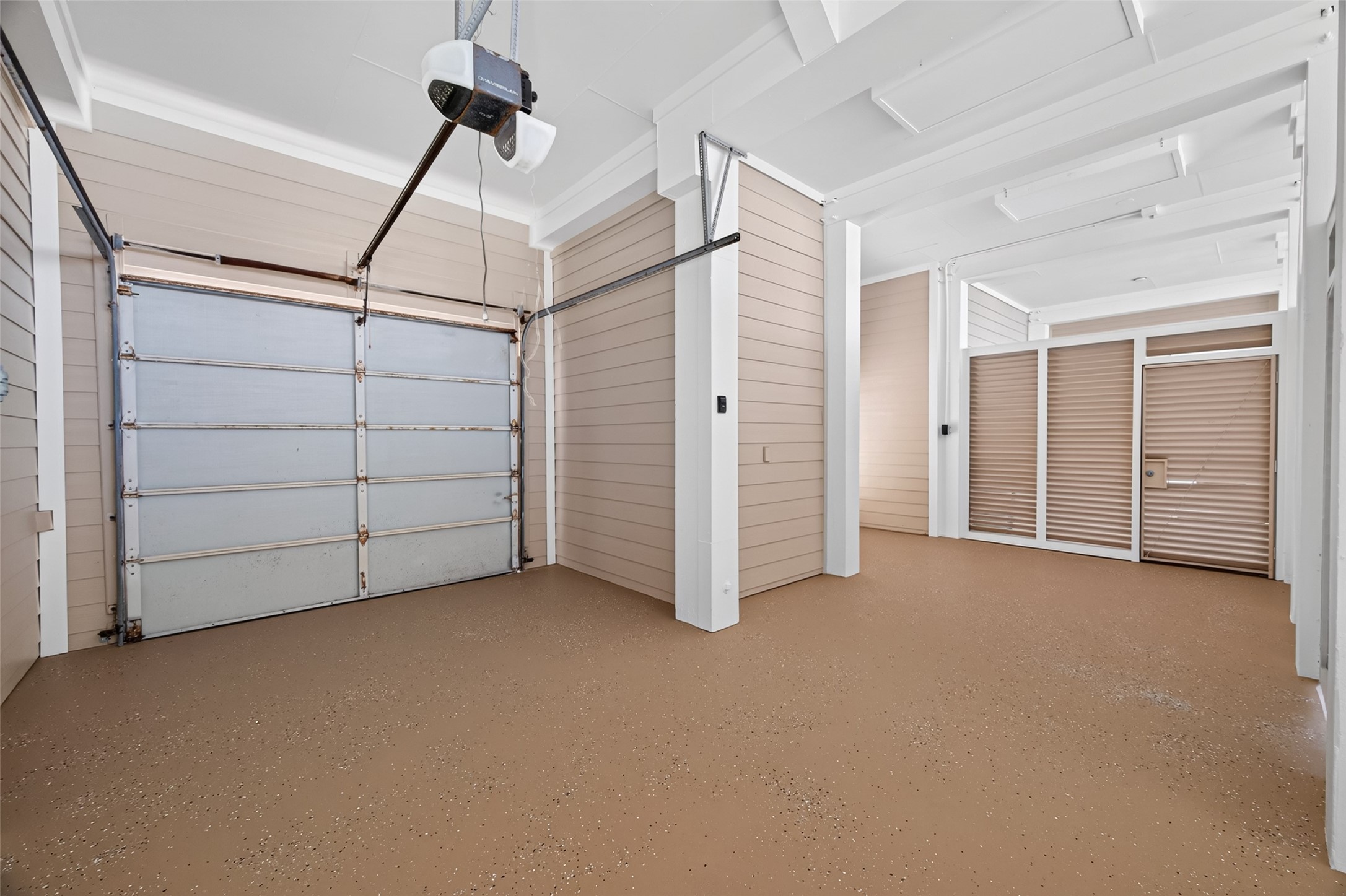 Spacious and well-lit garage with a modern automatic door and ample room for storage or parking.