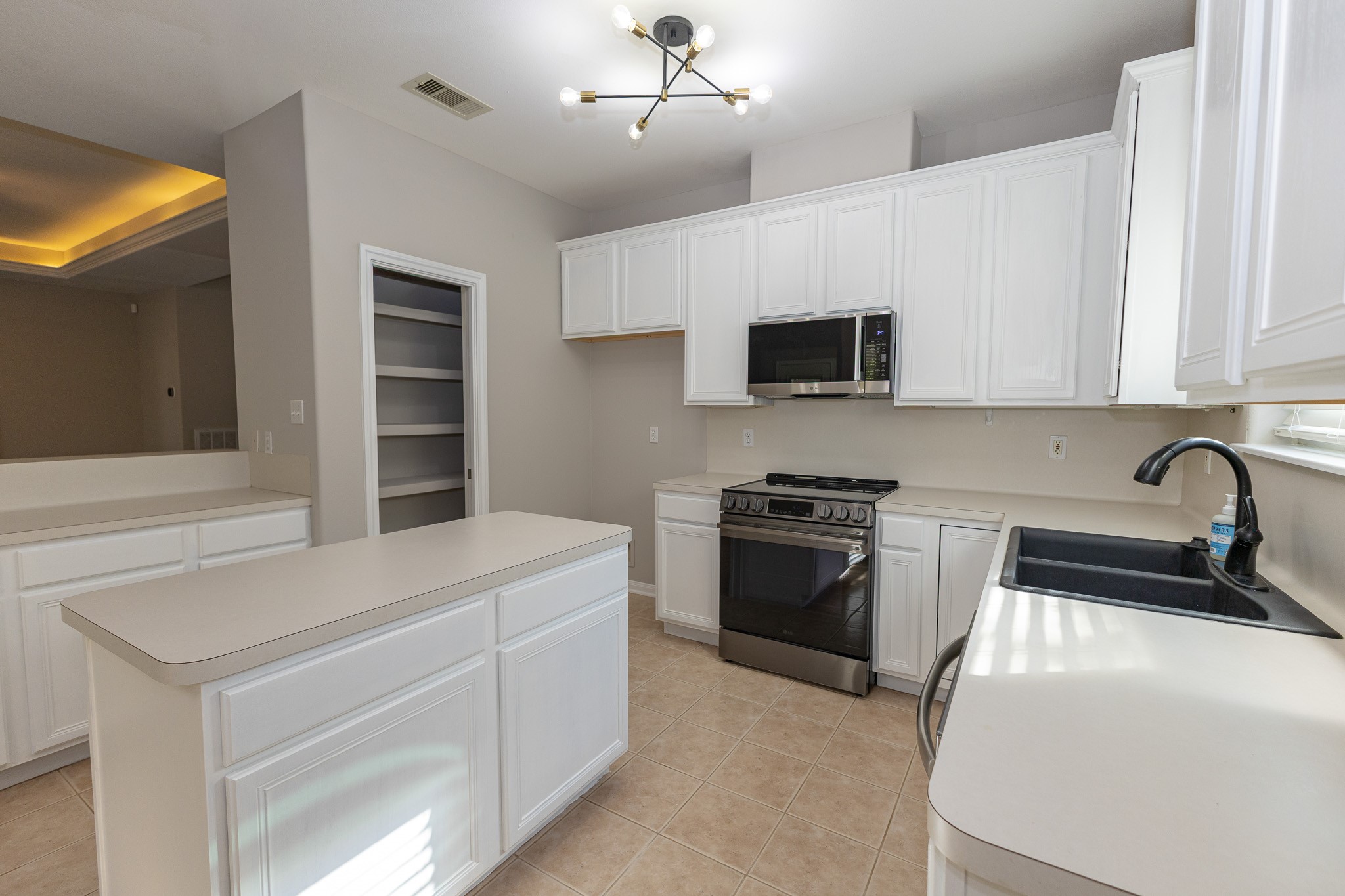 Bright, inviting kitchen featuring a new stove and microwave! Generous counter space and a convenient pantry provide plenty of storage and everyday functionality!