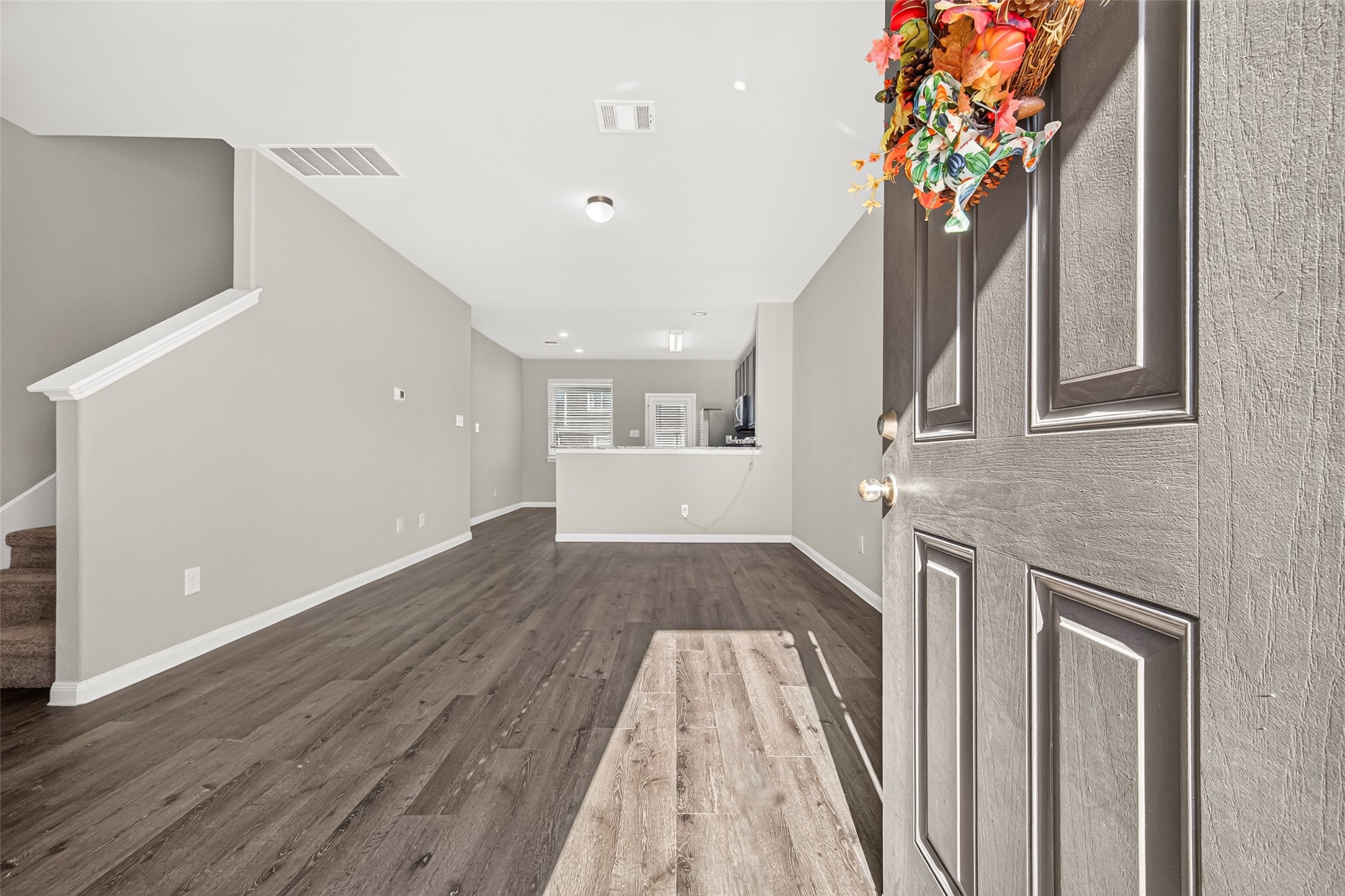 Step into this inviting open-concept living space featuring elegant luxury vinyl plank  floors, neutral tones, and a cozy atmosphere perfect for relaxation and entertaining.