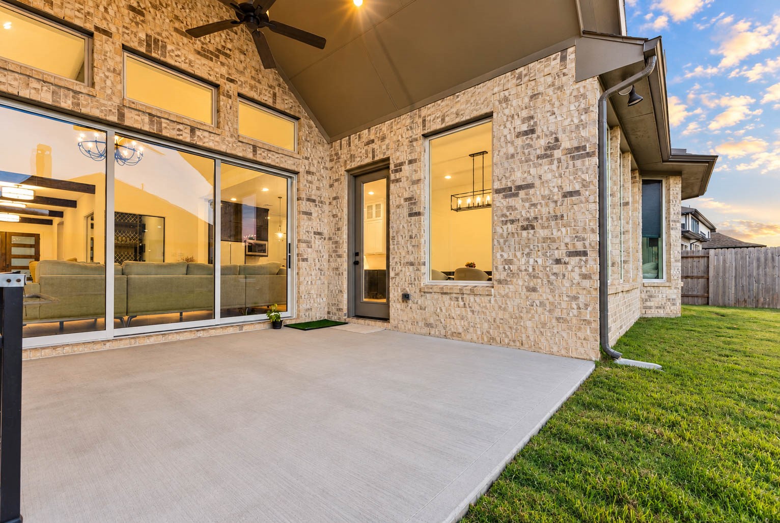 Elegant outdoor patio with a stylish brick facade and large sliding glass doors, seamlessly connecting indoor and outdoor living spaces.