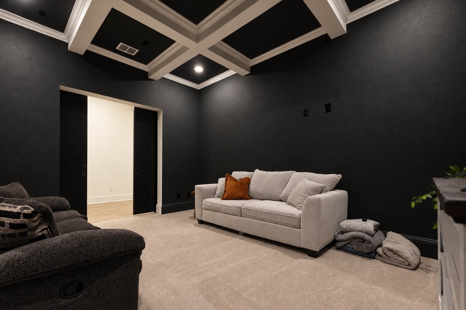 Elegant media room with dark walls and coffered ceiling, featuring dark colors painting. On the first floor. See yourself with family and friends watching a great movie or football game.