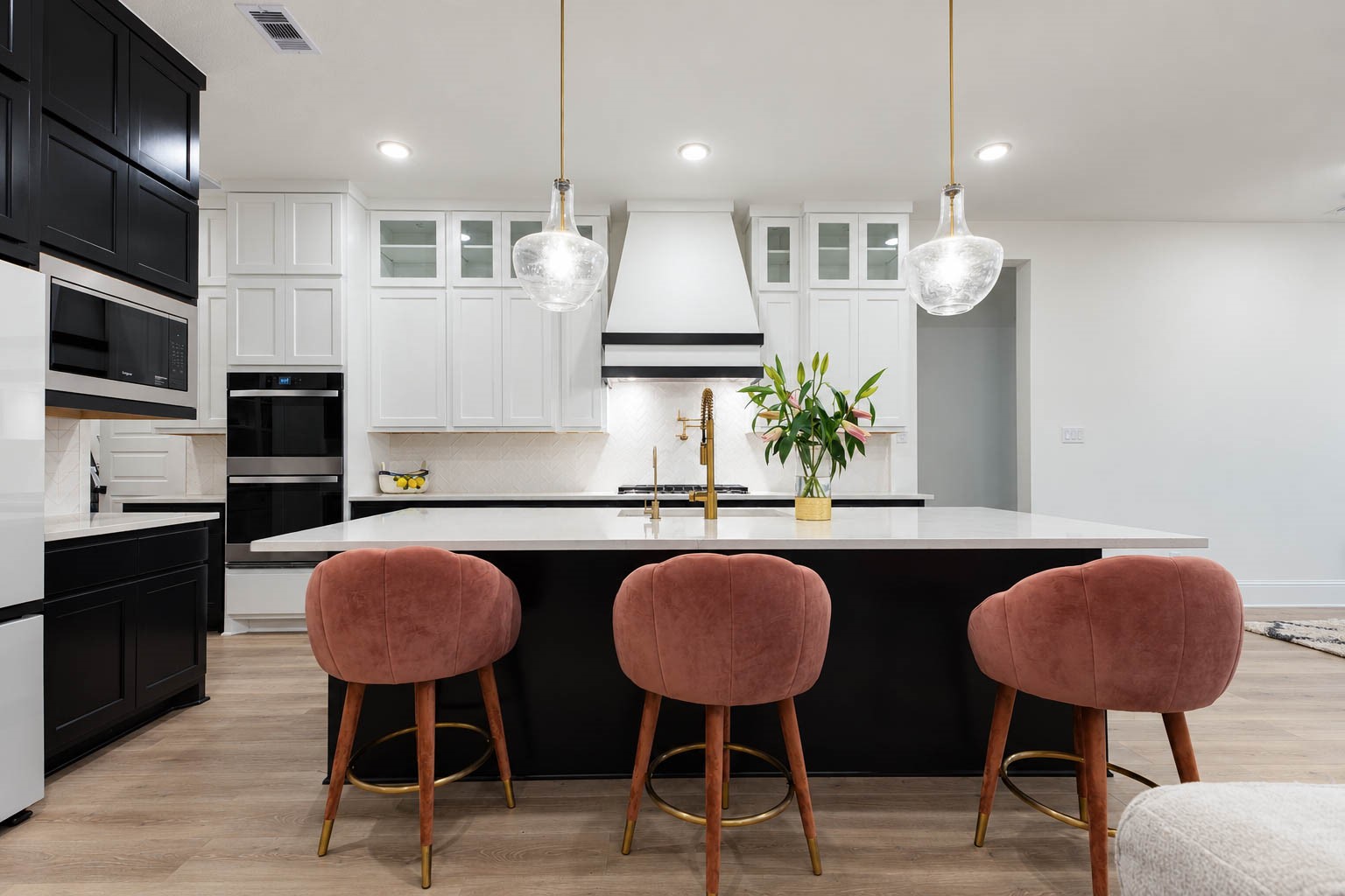 Discover a stylish kitchen featuring a large island with elegant pendant lighting, sleek two-tone cabinetry.