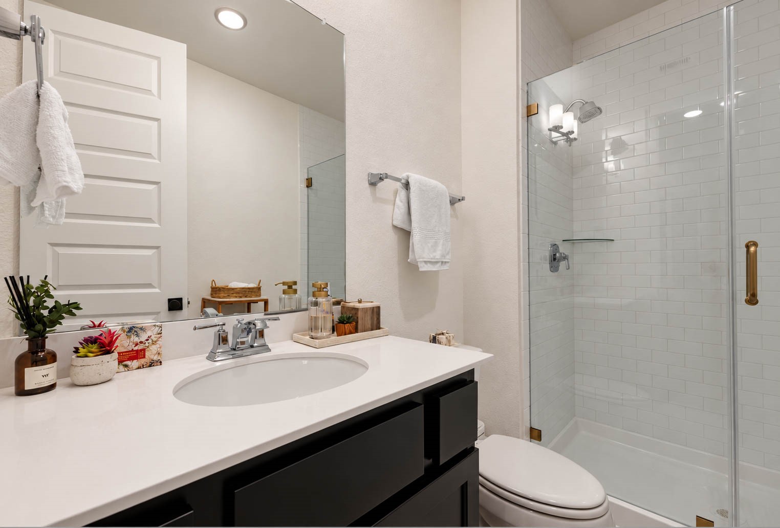 Modern bathroom with a sleek vanity, spacious glass-enclosed shower, and elegant fixtures, offering a clean and inviting atmosphere.