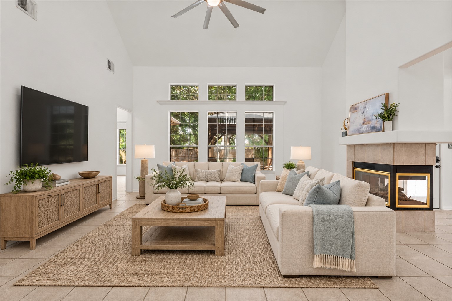 Oversized family room with vaulted ceilings, tons of natural light, and a three-sided fireplace shared with the breakfast area. Virtually staged.