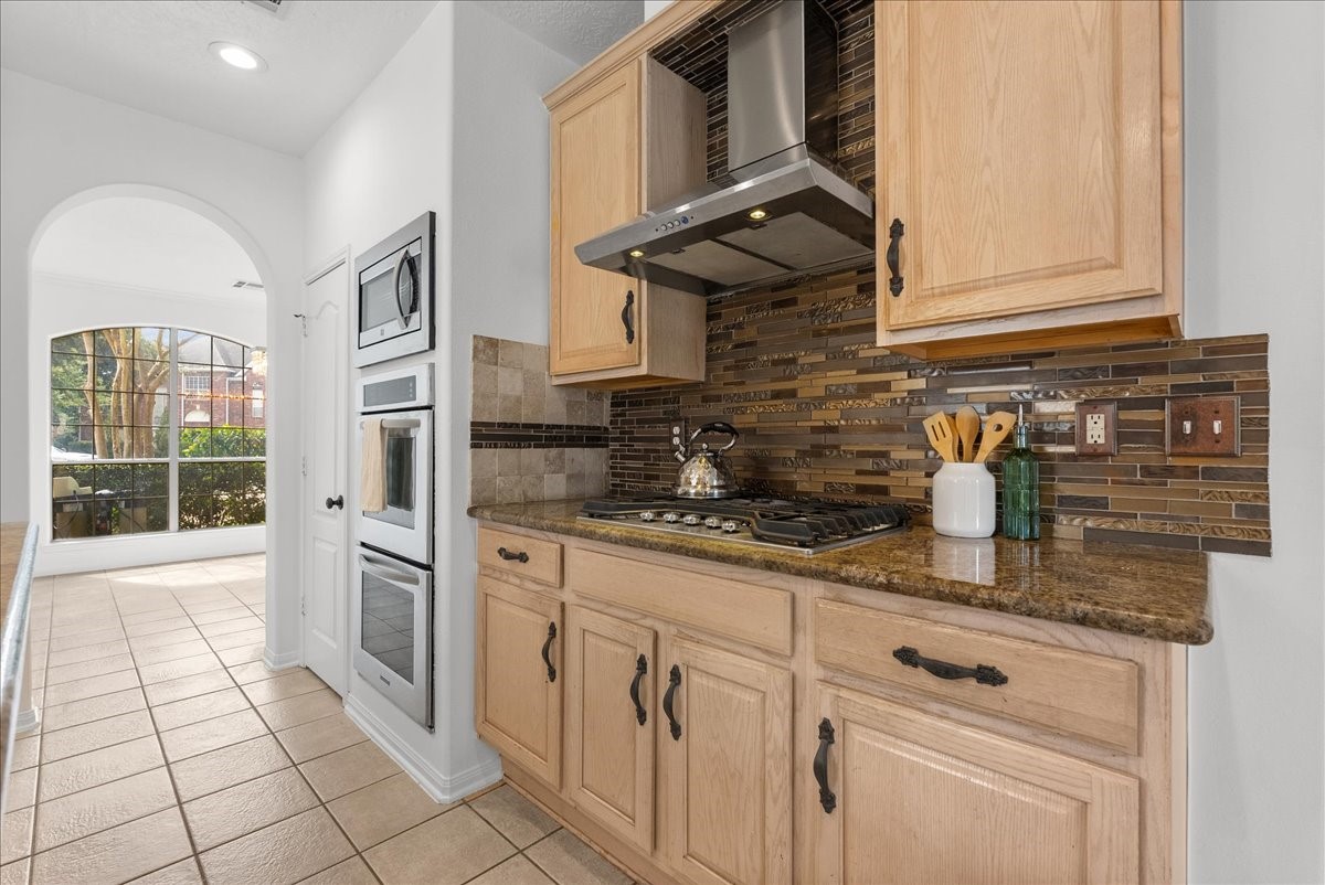This kitchen is ready for you and your gourmet meals!! Gas cooktop with a stainless vent hood, mosaic tile backsplash, and double wall ovens.
