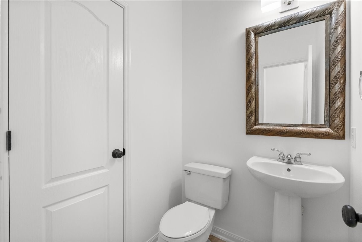 Convenient half bath for guests with a pedestal sink located on the 1st floor.