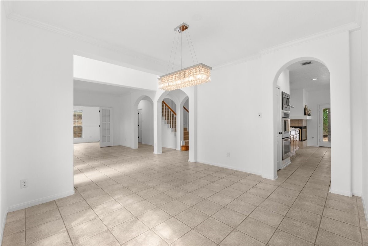 View from the dining room toward the kitchen and entry, showing the easy flow and beautiful arched doorways.