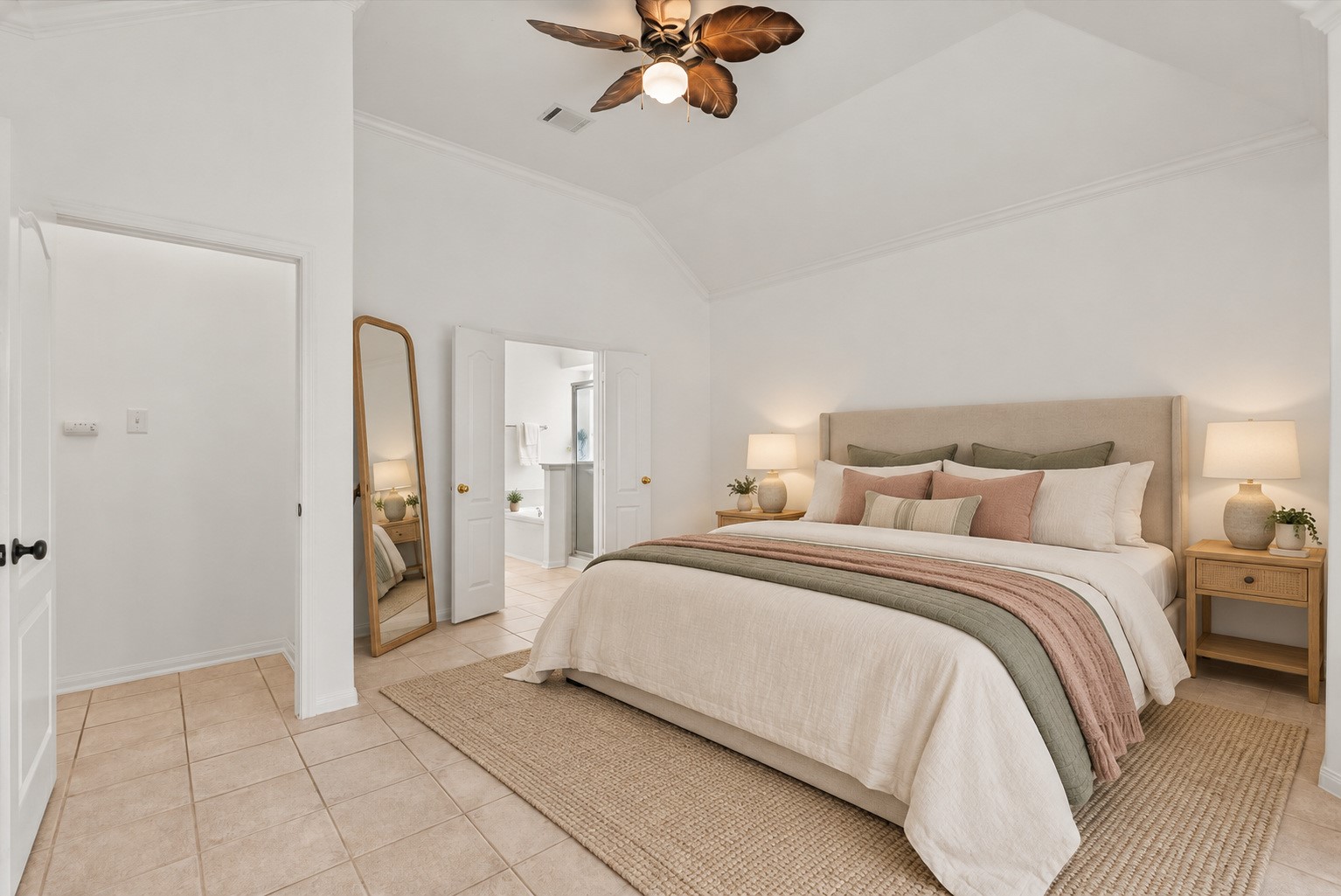 The primary bedroom offers a vaulted ceiling and an easy access to the en suite bath. Virtually staged.