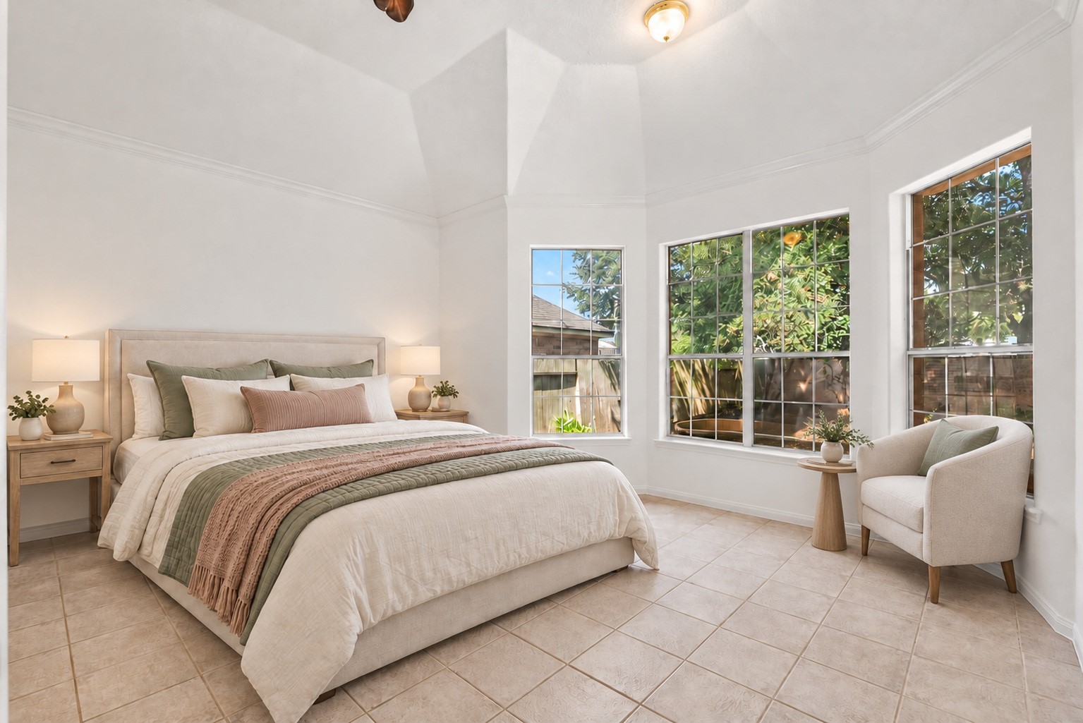 Tranquil primary bedroom with a bay window sitting area overlooking the backyard. Virtually staged.