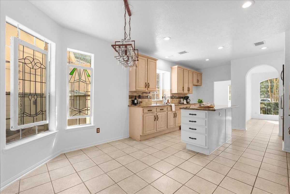 Breakfast area flowing right into the kitchen, with stained glass accents and lots of natural light.