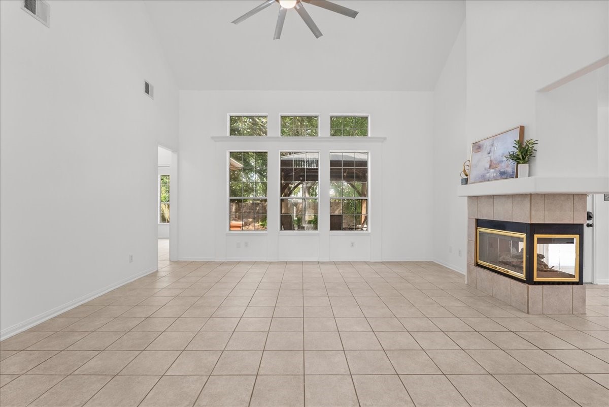 Oversized family room with vaulted ceilings, tons of natural light, and a three-sided fireplace shared with the breakfast area.