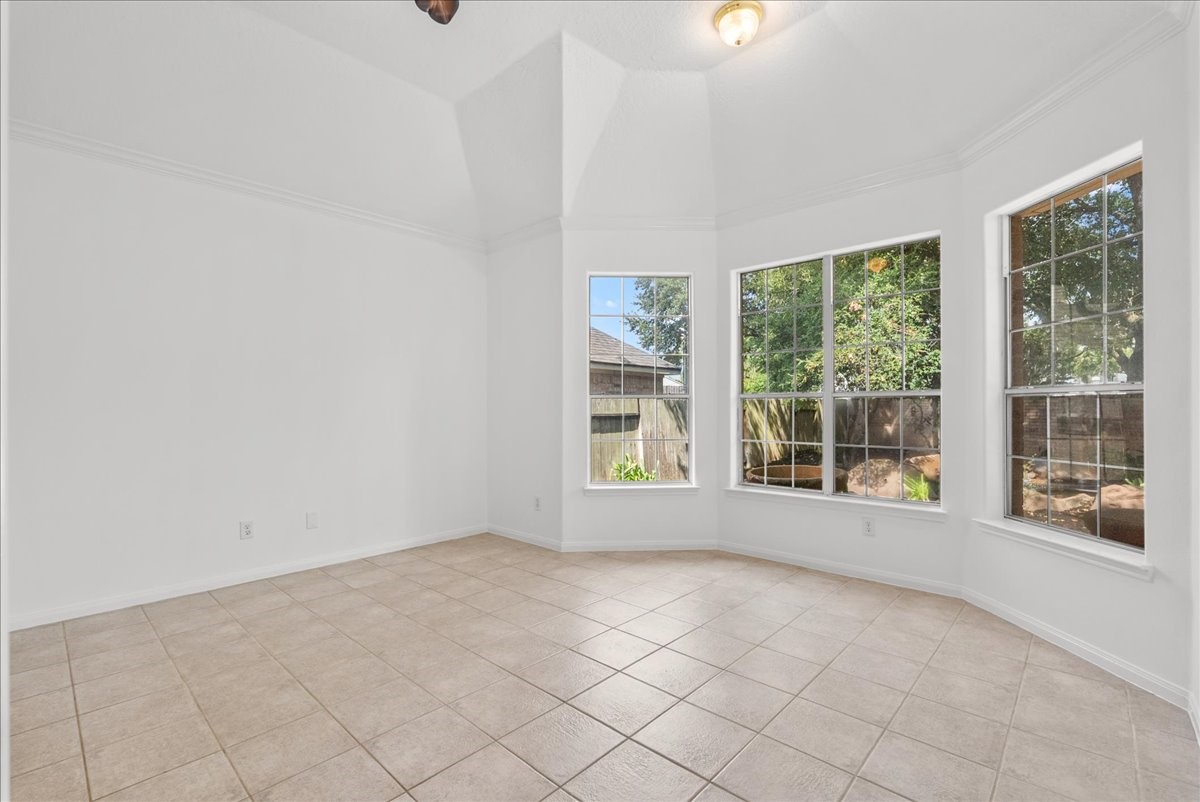 Tranquil primary bedroom with a bay window sitting area overlooking the backyard.