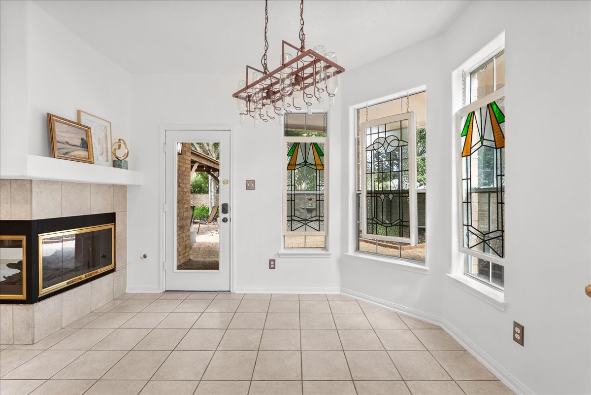 Breakfast area with custom hanging stained glass windows and backyard access. For those cooler mornings, imaging coffee and breakfast by the fire.