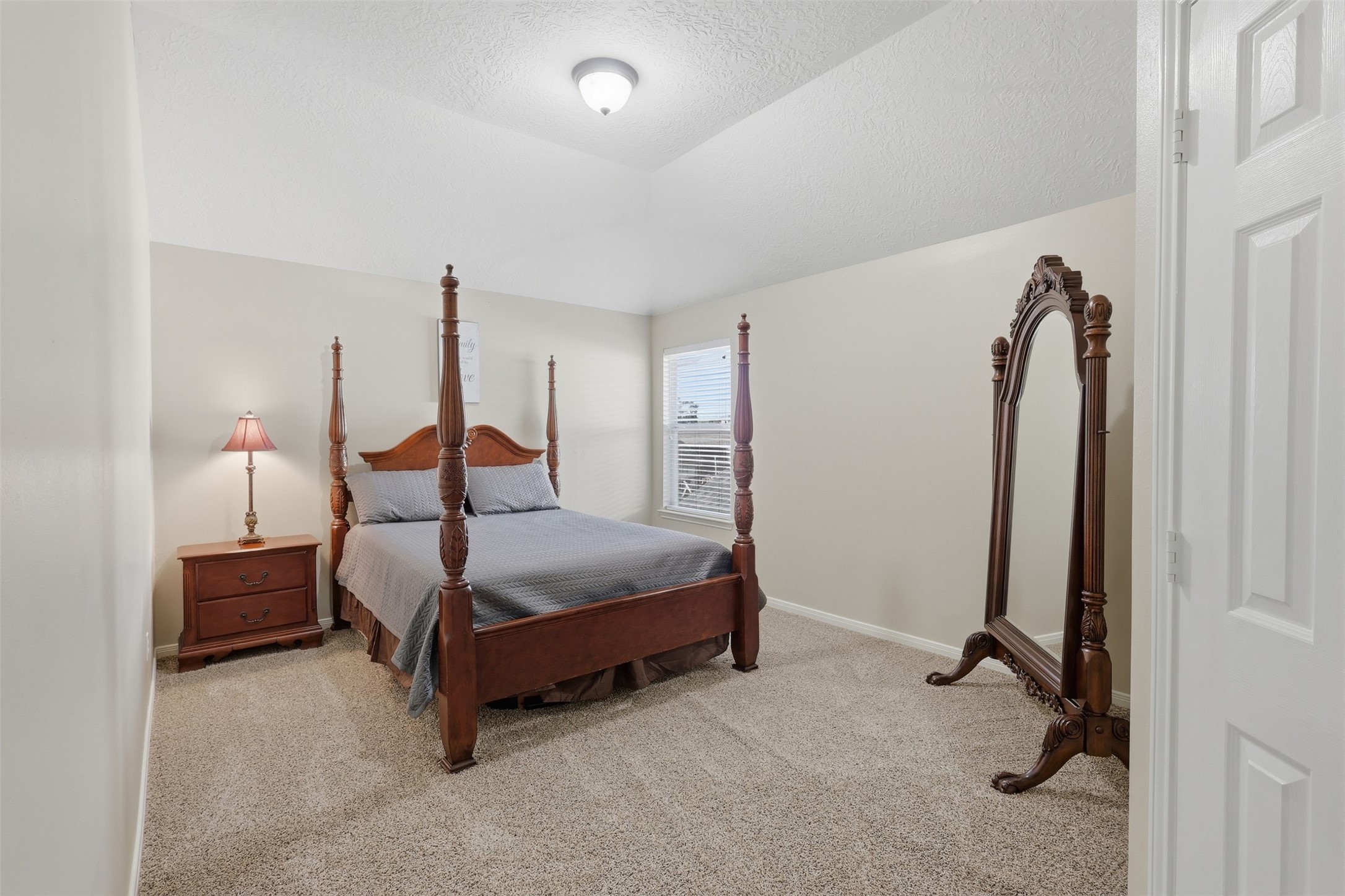 Spacious secondary bedroom with plush carpeting, high ceilings, abundant natural light, and ample floor space. This comfortable private retreat offers plenty of room for furniture and personal touches, complete with a walk-in closet.