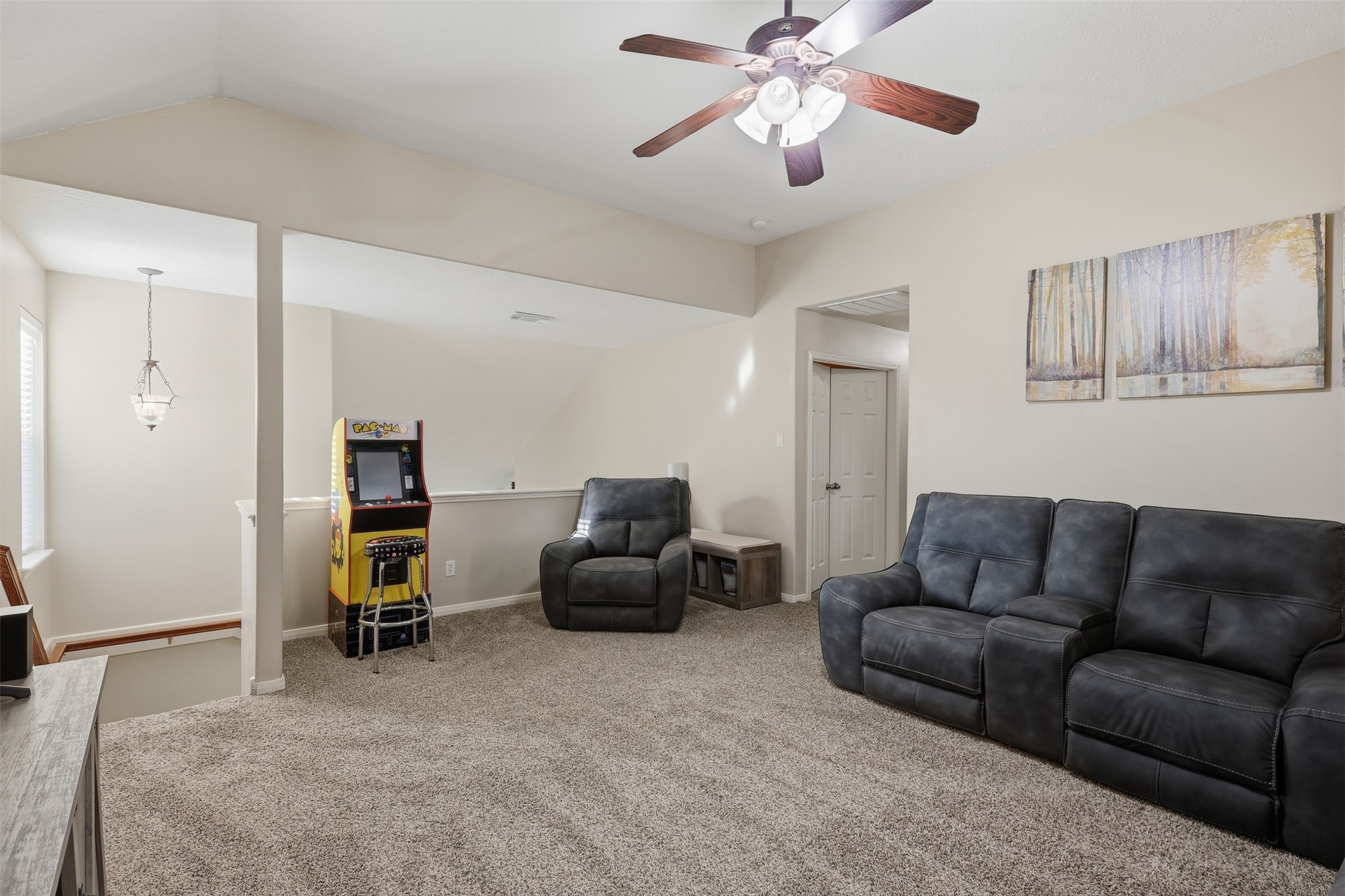 Spacious upstairs game room provides a comfortable and versatile retreat with plush carpeting, ceiling fan, comfortable seating, and plenty of room for recreation and entertaining. A bright, open space ready for family game nights and casual gatherings.