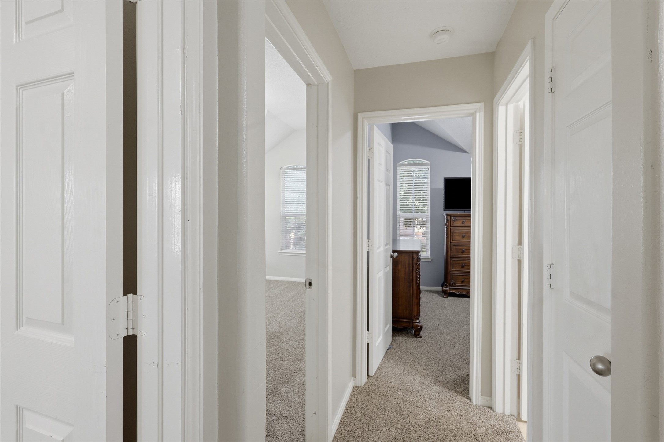Well-appointed upstairs hallway provides convenient access to the home's bedrooms and entertainment spaces. Soft carpeting, neutral finishes, and plenty of natural light create a comfortable and welcoming upper-level passage.