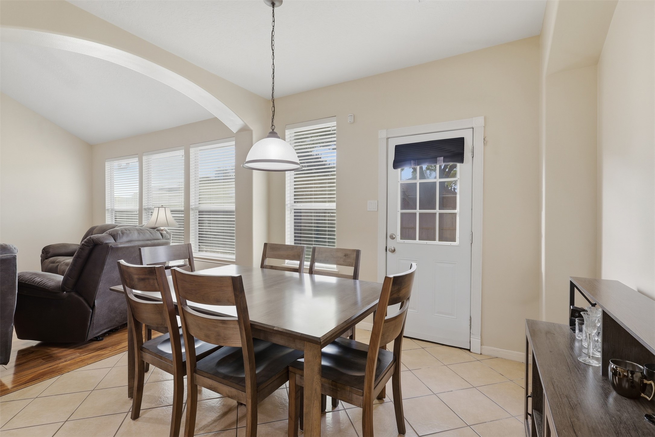 Bright and inviting breakfast room features a charming dining area, tile flooring, stylish pendant lighting, and abundant natural light. The space opens beautifully to the main living areas, creating an ideal spot for casual family meals and morning coffee.