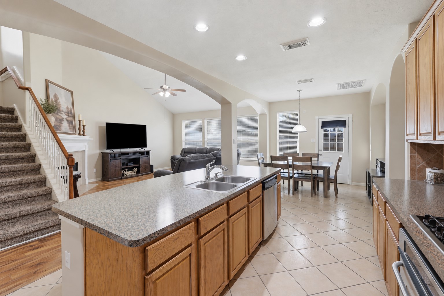Spacious open-concept kitchen and family room create the perfect gathering space. The large island provides generous workspace and seating, while the kitchen flows seamlessly into the breakfast area and bright family room. Beautiful wood-look flooring and soaring ceilings add warmth and dimension.