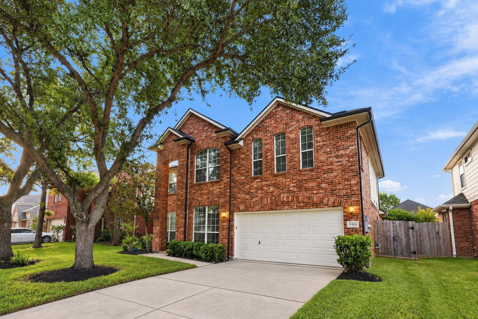Charming brick elevation showcases a beautifully maintained front yard, mature shade trees, tall windows, and a generous driveway leading to the oversized 2.5-car garage. A wonderful first impression of this spacious Shadow Creek Ranch home!