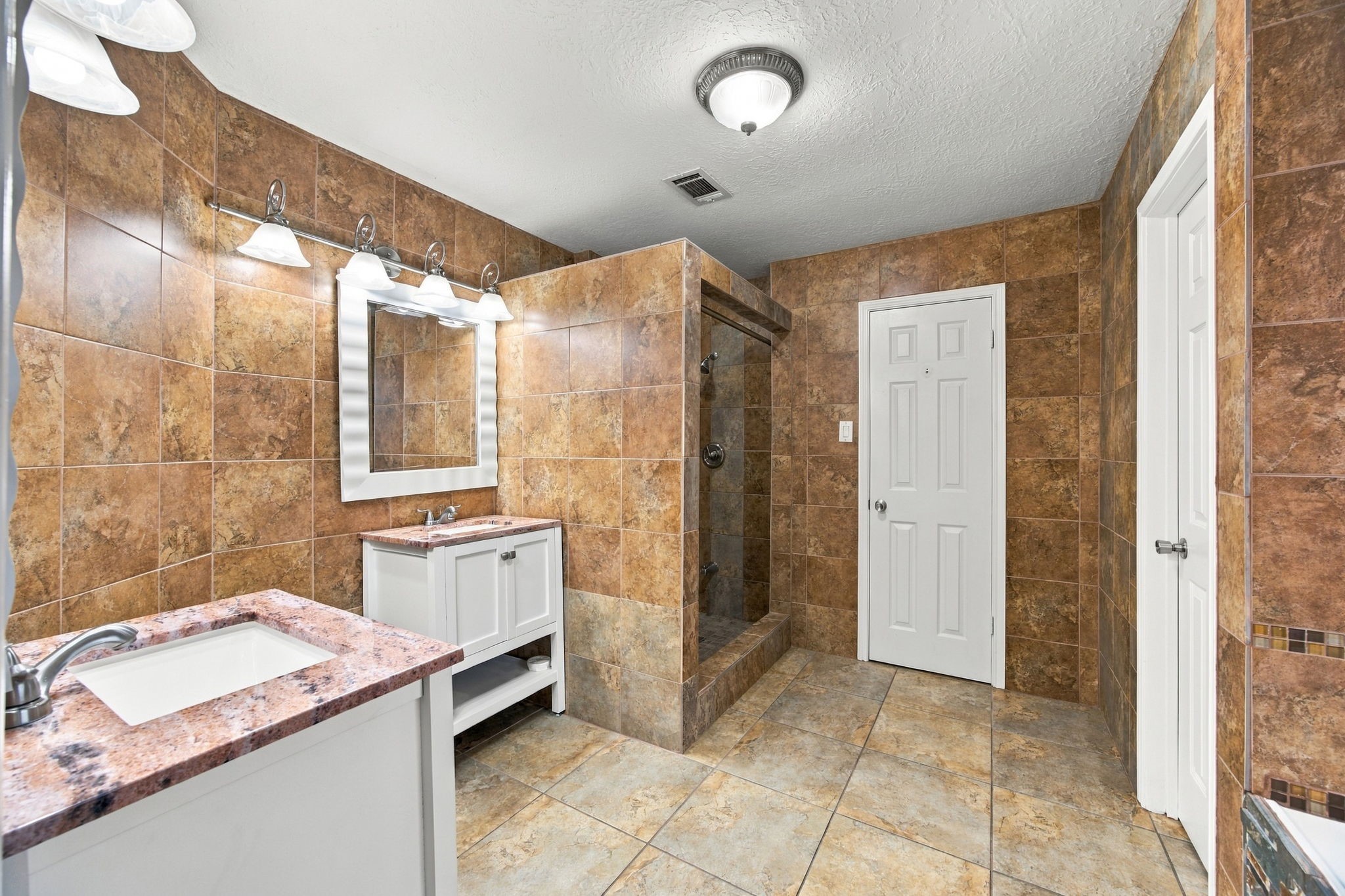 Two individual vanities provide dedicated space for daily routines, each with its own mirror and lighting.