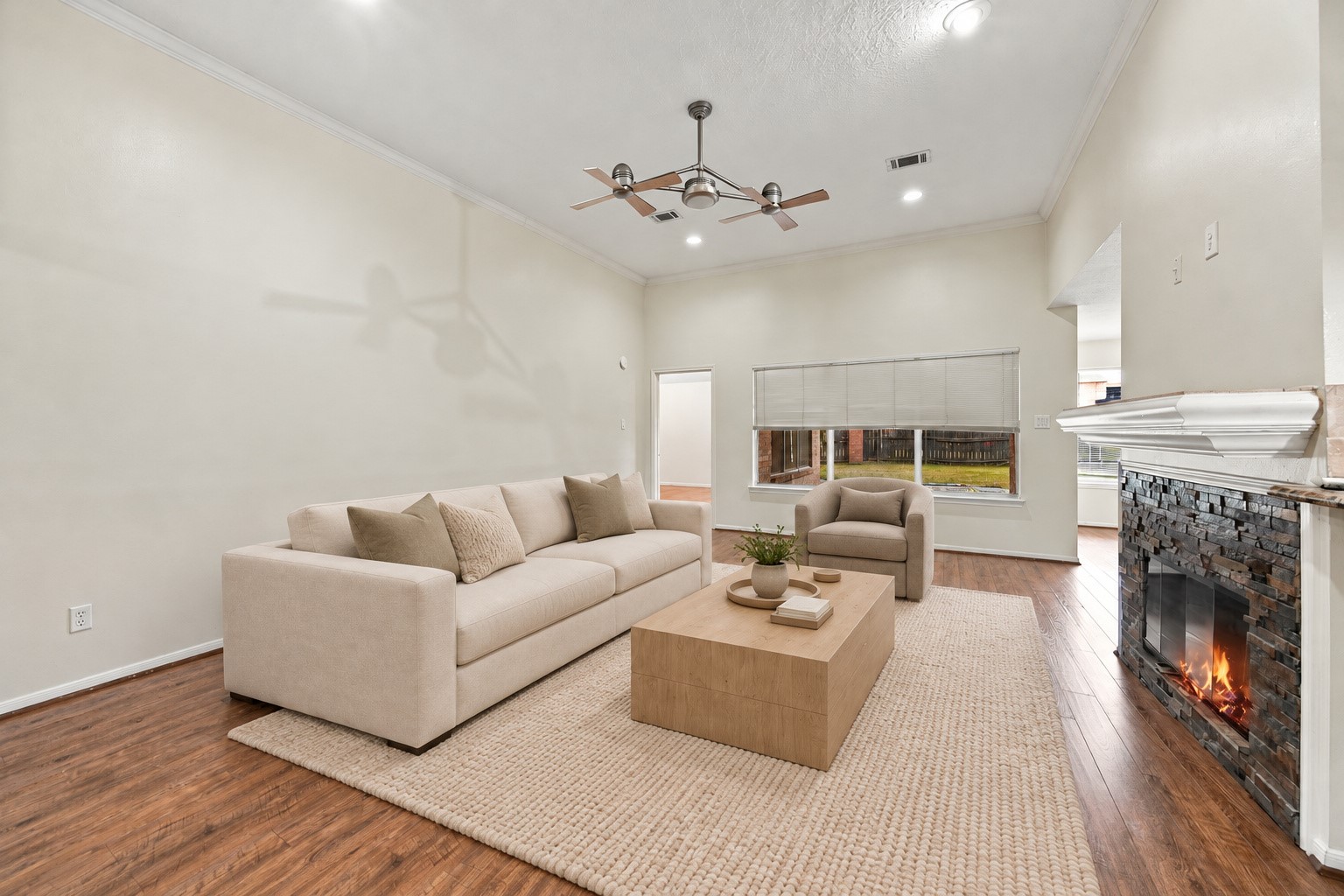 An expansive wall provides flexible furniture placement, while a wide window brings in natural light. Virtually staged