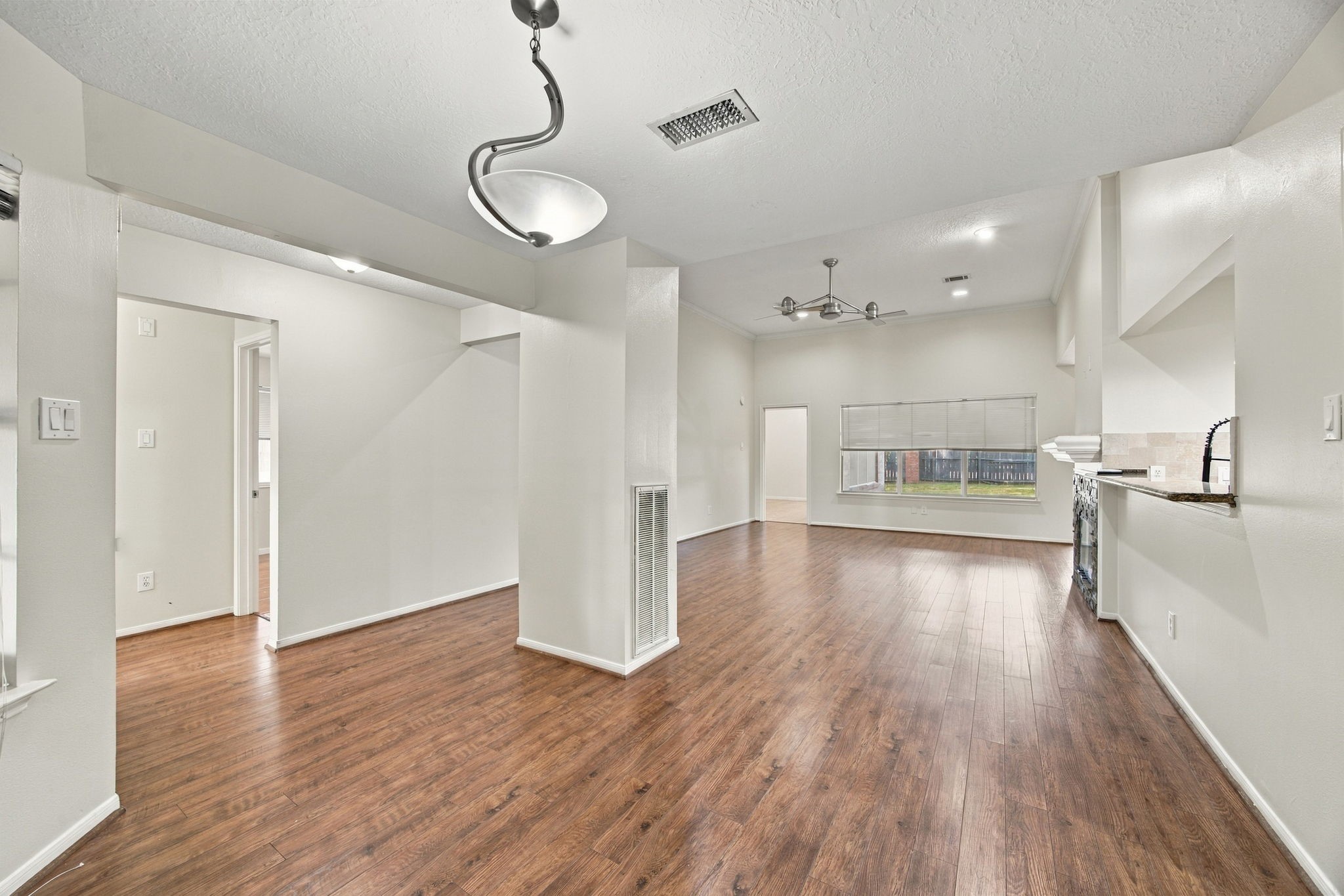 This view highlights the flow from the front dining area toward the living room, with the kitchen alongside