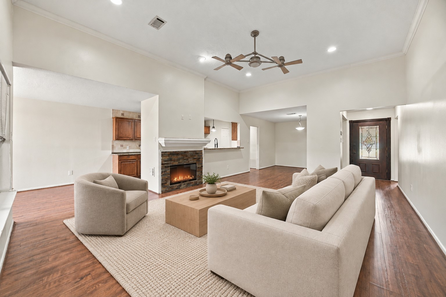 High ceilings, crown molding, and recessed lighting give the main gathering space an airy feel. Virtually staged.
