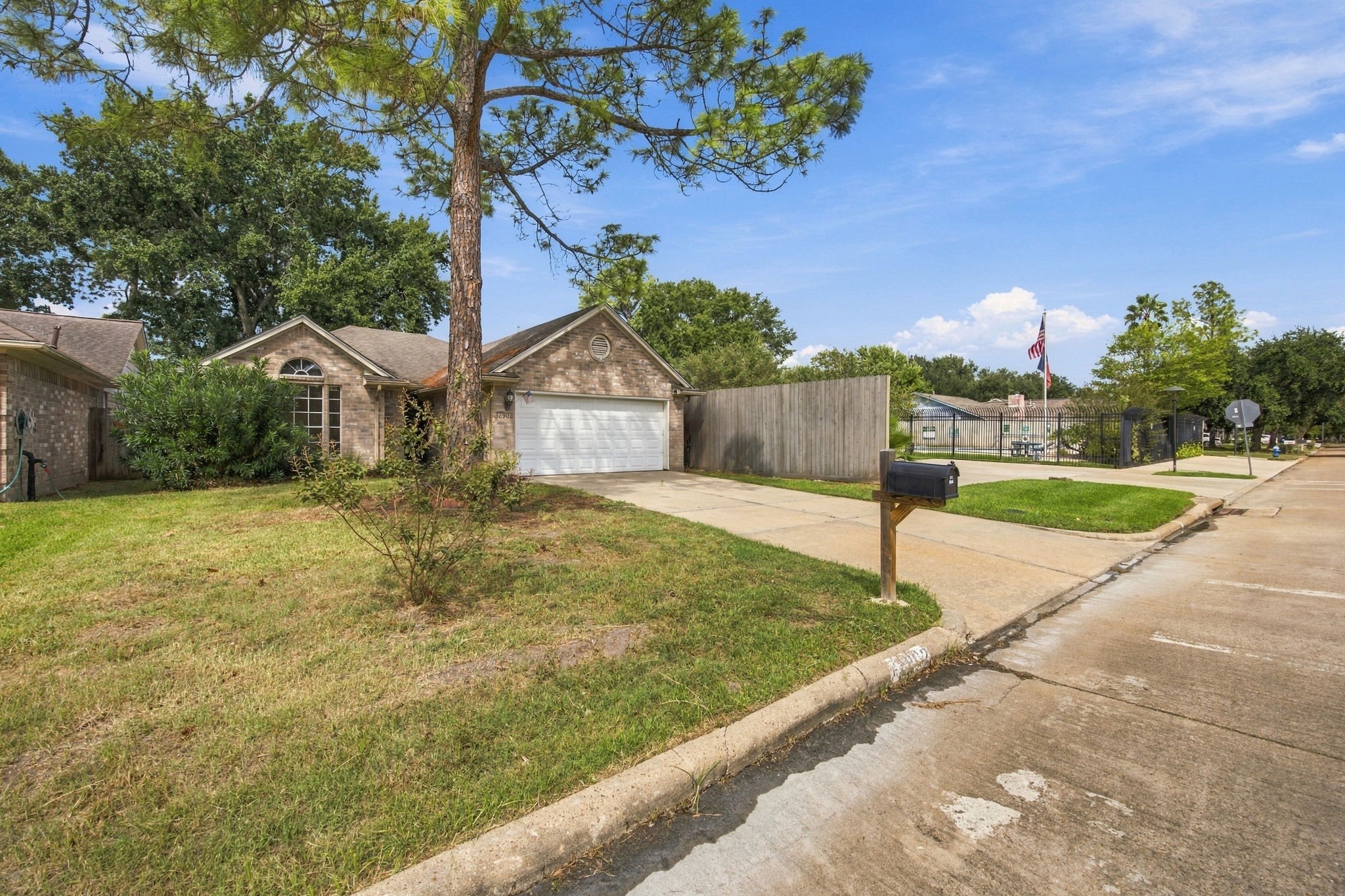 A wider view highlights the front lawn and the homes setting along the residential street.